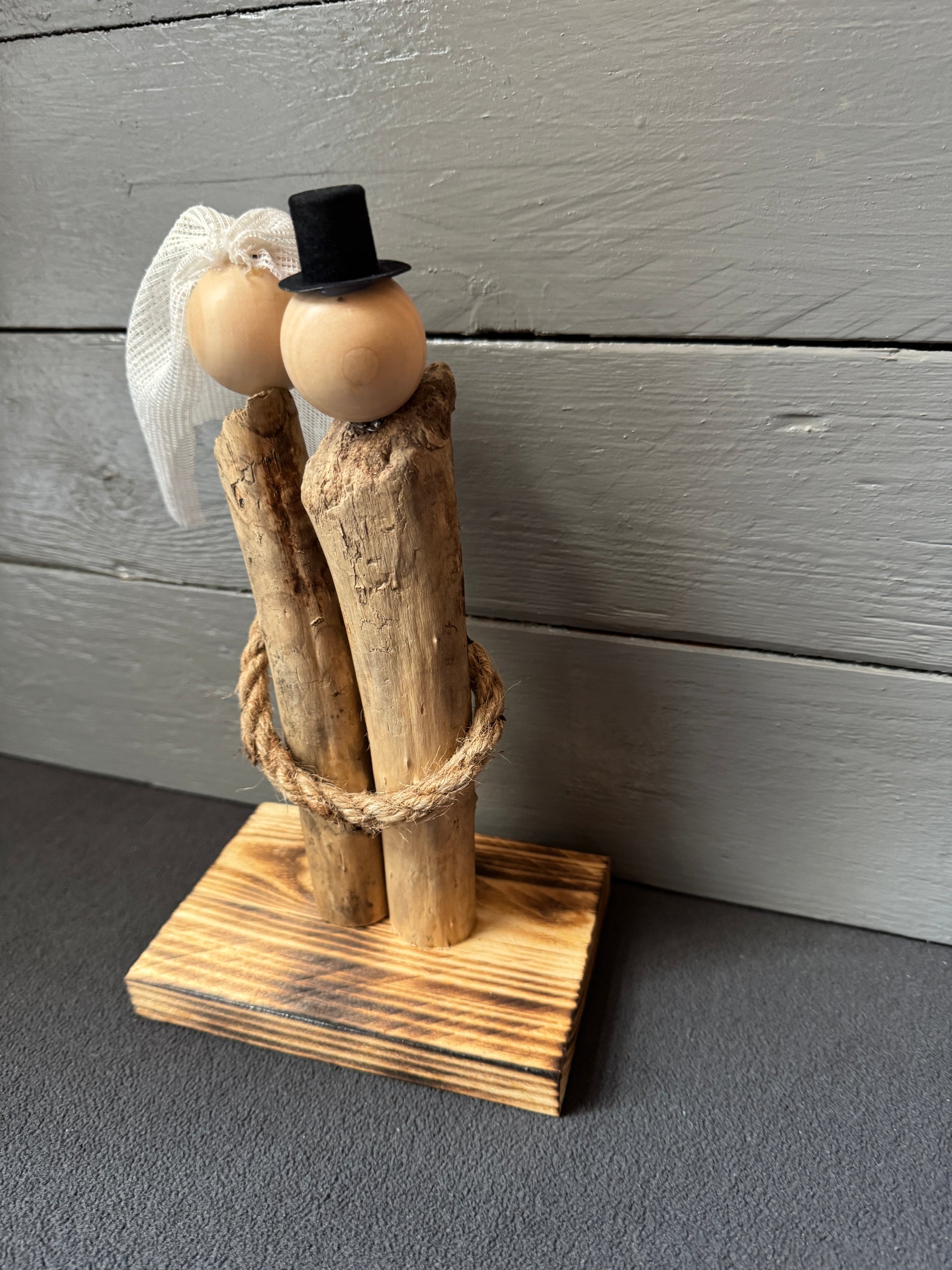 Elegantes, zeitloses Treibholz-Brautpaar mit Zylinder und Schleier – nachhaltige Hochzeitsdekoration aus naturfarbenem Treibholz