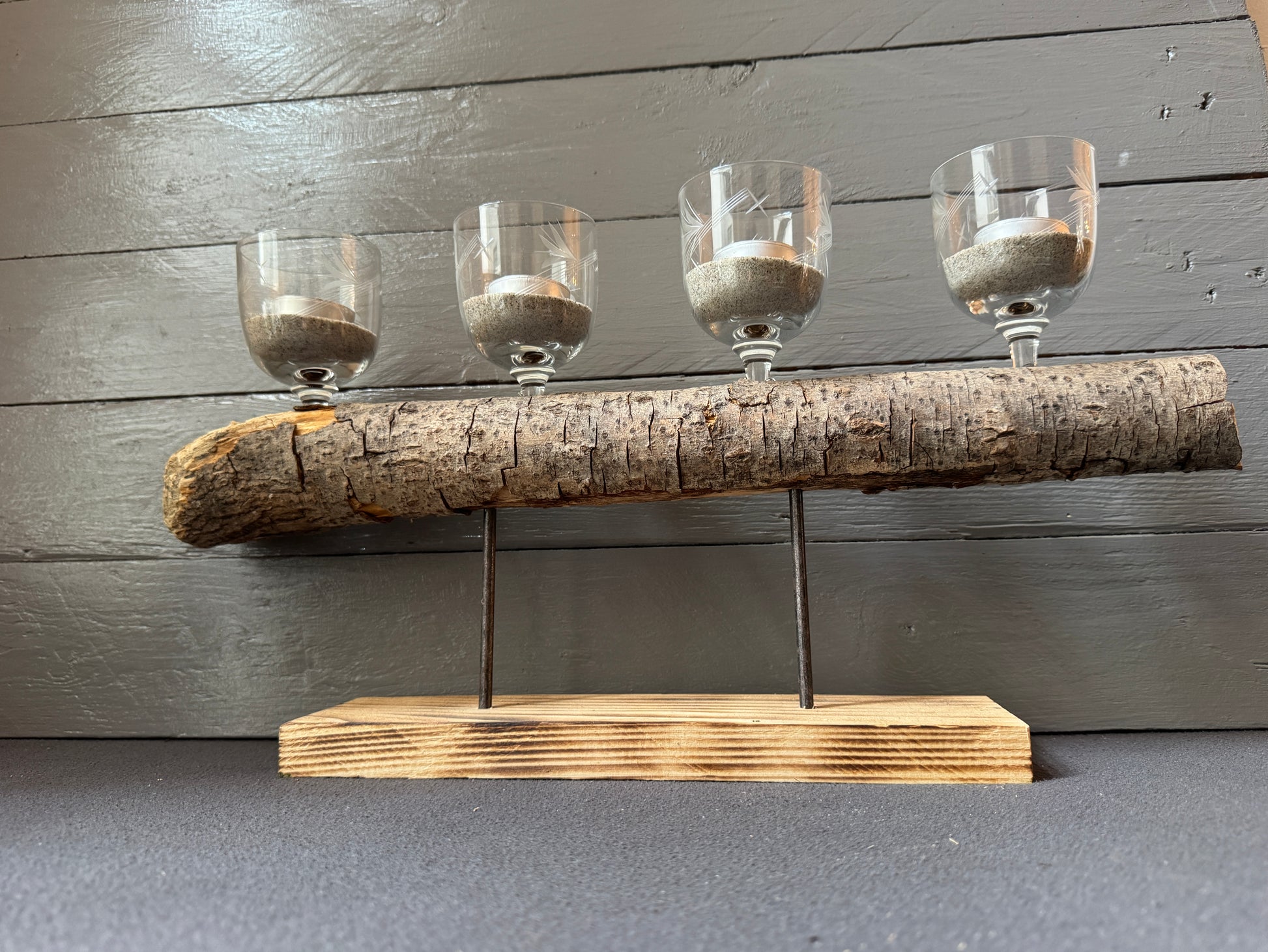 Seitliche Ansicht: Treibholz auf recyceltem Palettenholzfuß mit vier Teelicht-Gläsern