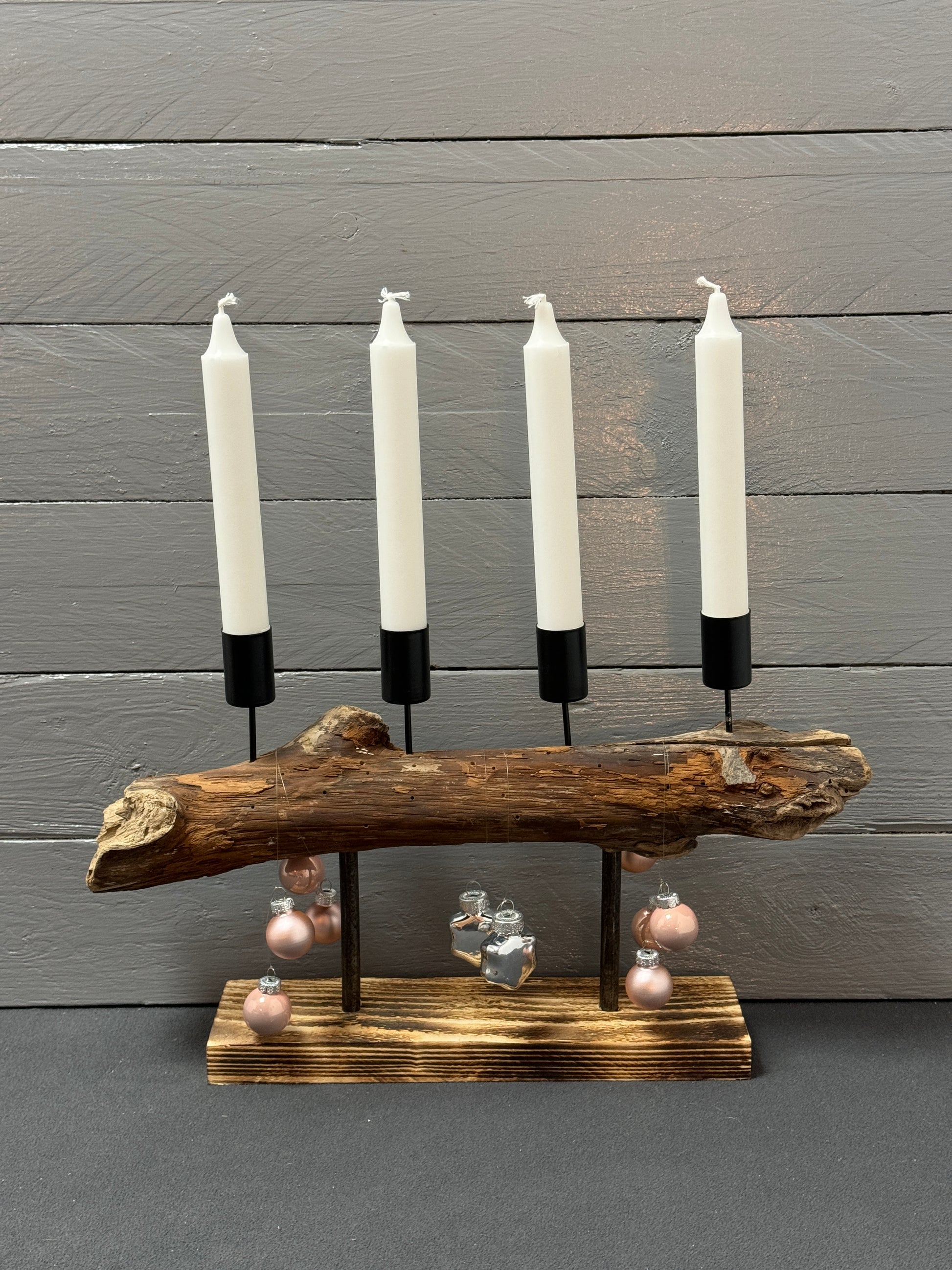 Adventsgesteck aus Treibholz mit rosa Kugeln auf Palettenholz-Sockel