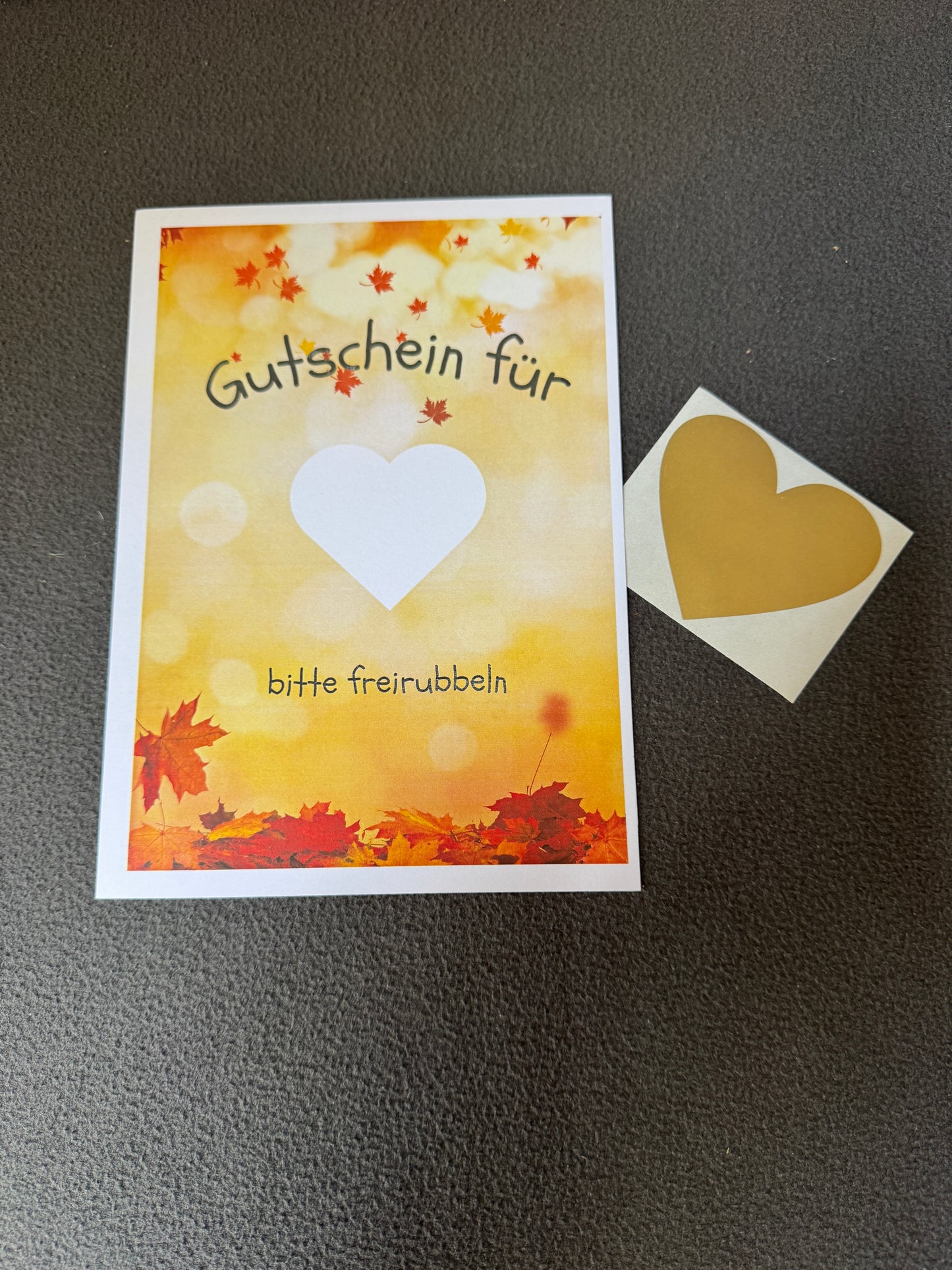 Herbstliches Rubbellos „Gutschein“ mit goldenem Rubbelherz für persönliche Nachrichten im DIN A5-Format.