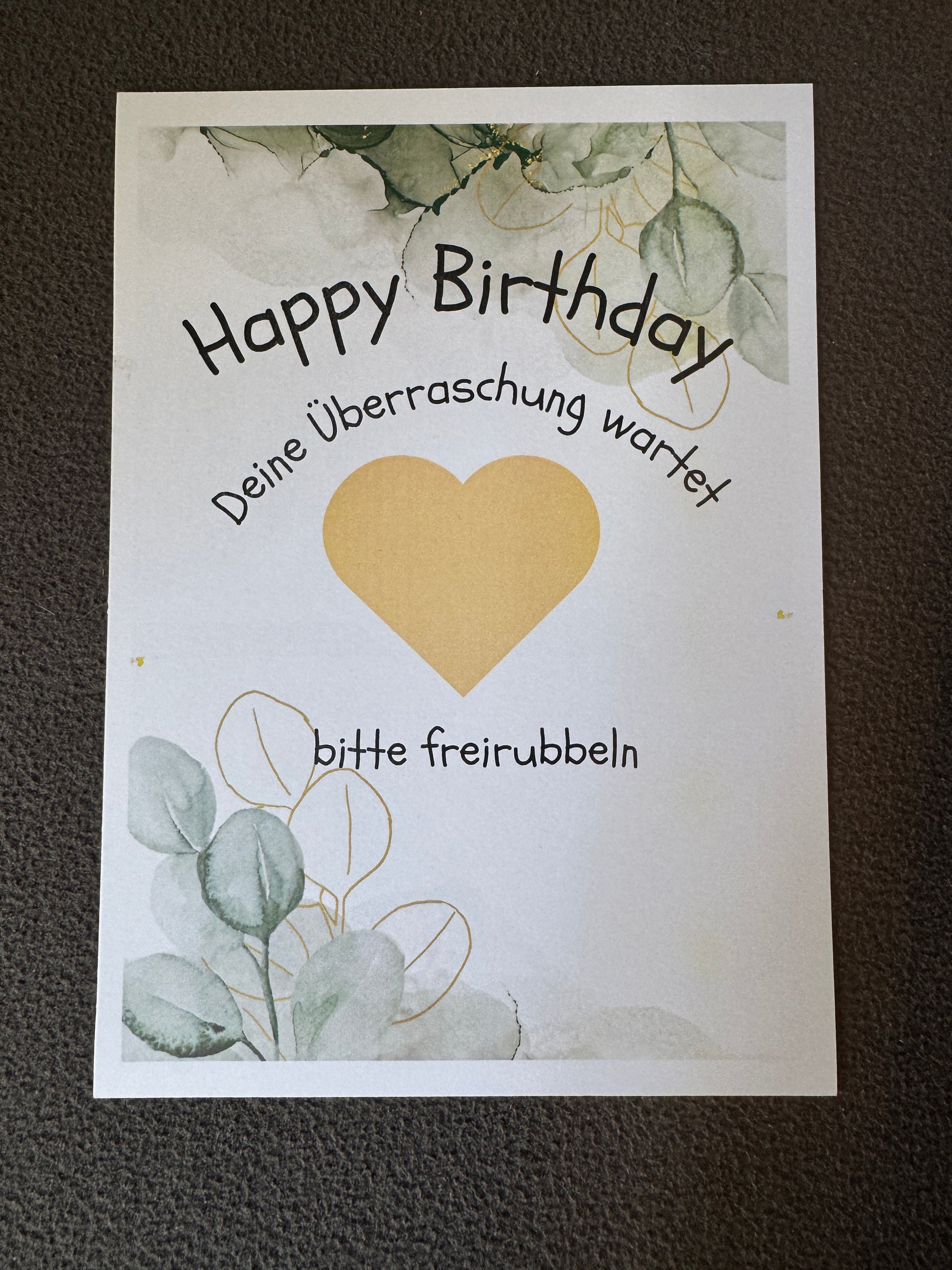 Nahaufnahme des goldenen Rubbelherzes auf Geburtstagskarte