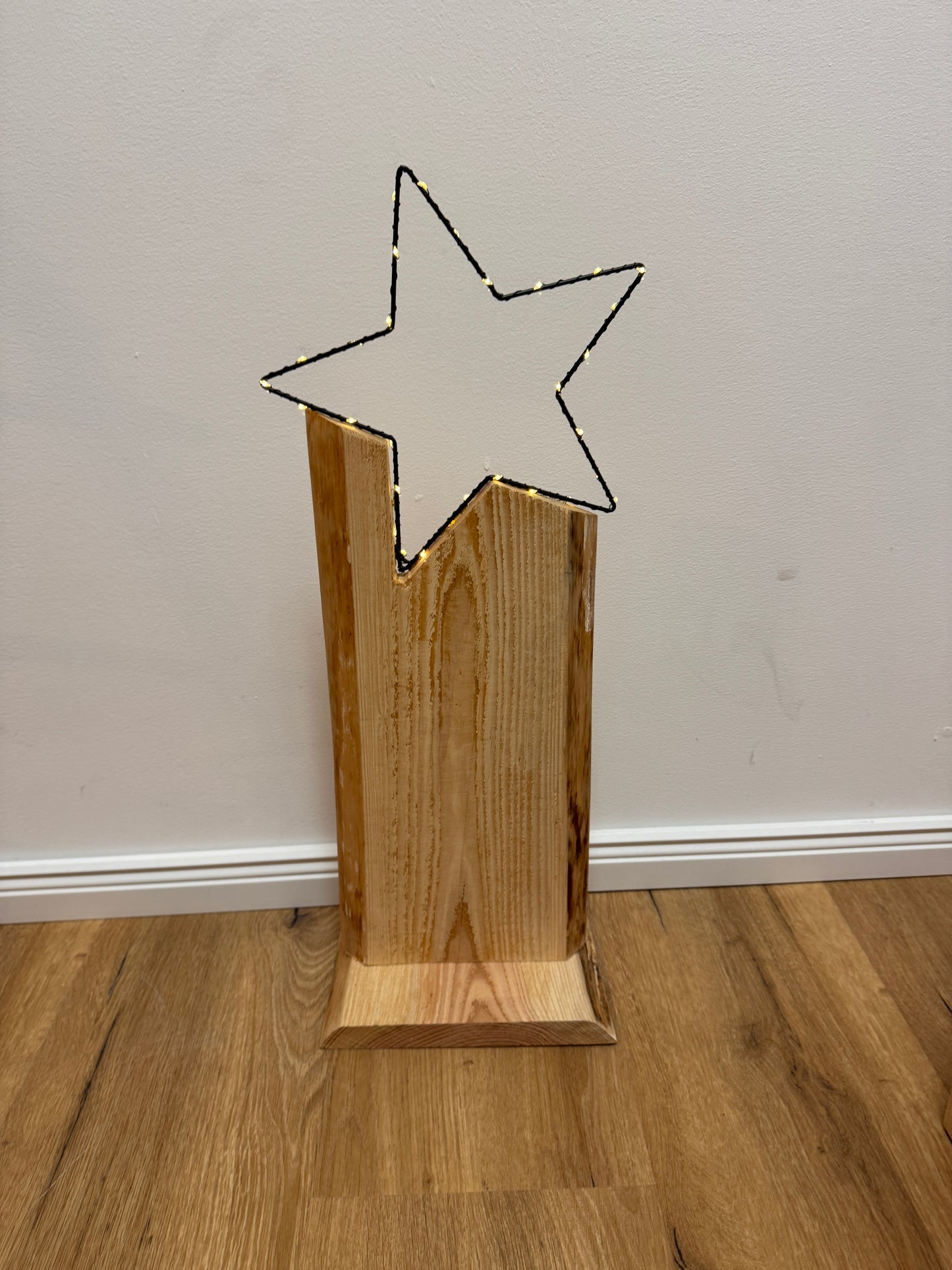 Detailaufnahme LED-Stern auf Holzstele – warmweiße Lichtpunkte auf filigranem Sternrahmen, naturbelassenes Holz.