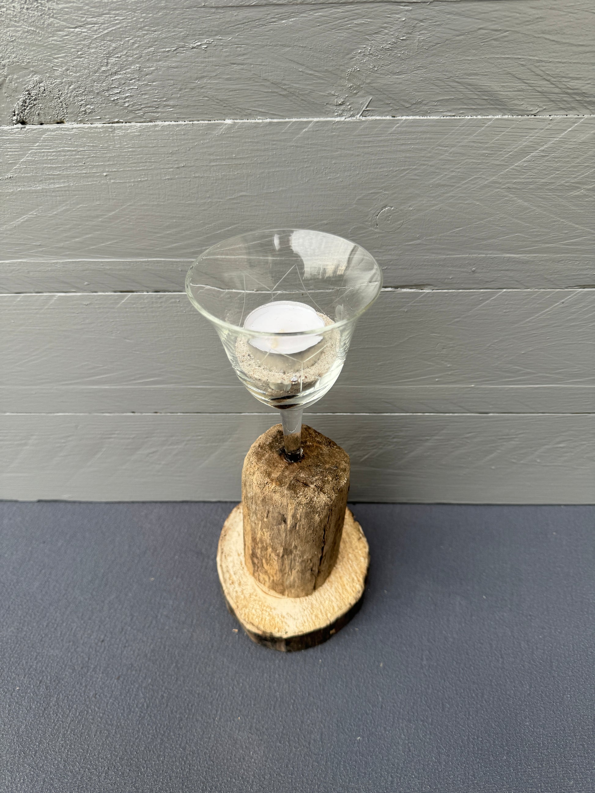 Weinglas-Teelichthalter mit Ostseesand auf rustikalem Holzfuß