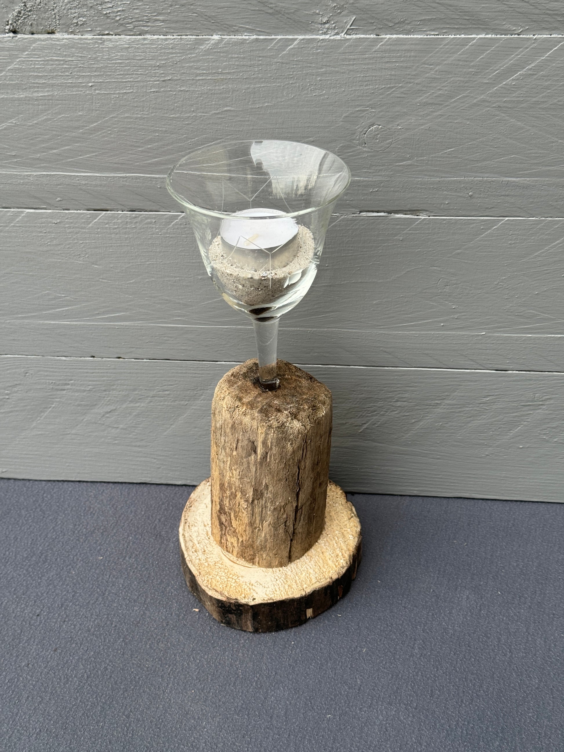 Treibholz-Kerzenständer auf runder Holzscheibe mit Weinglas