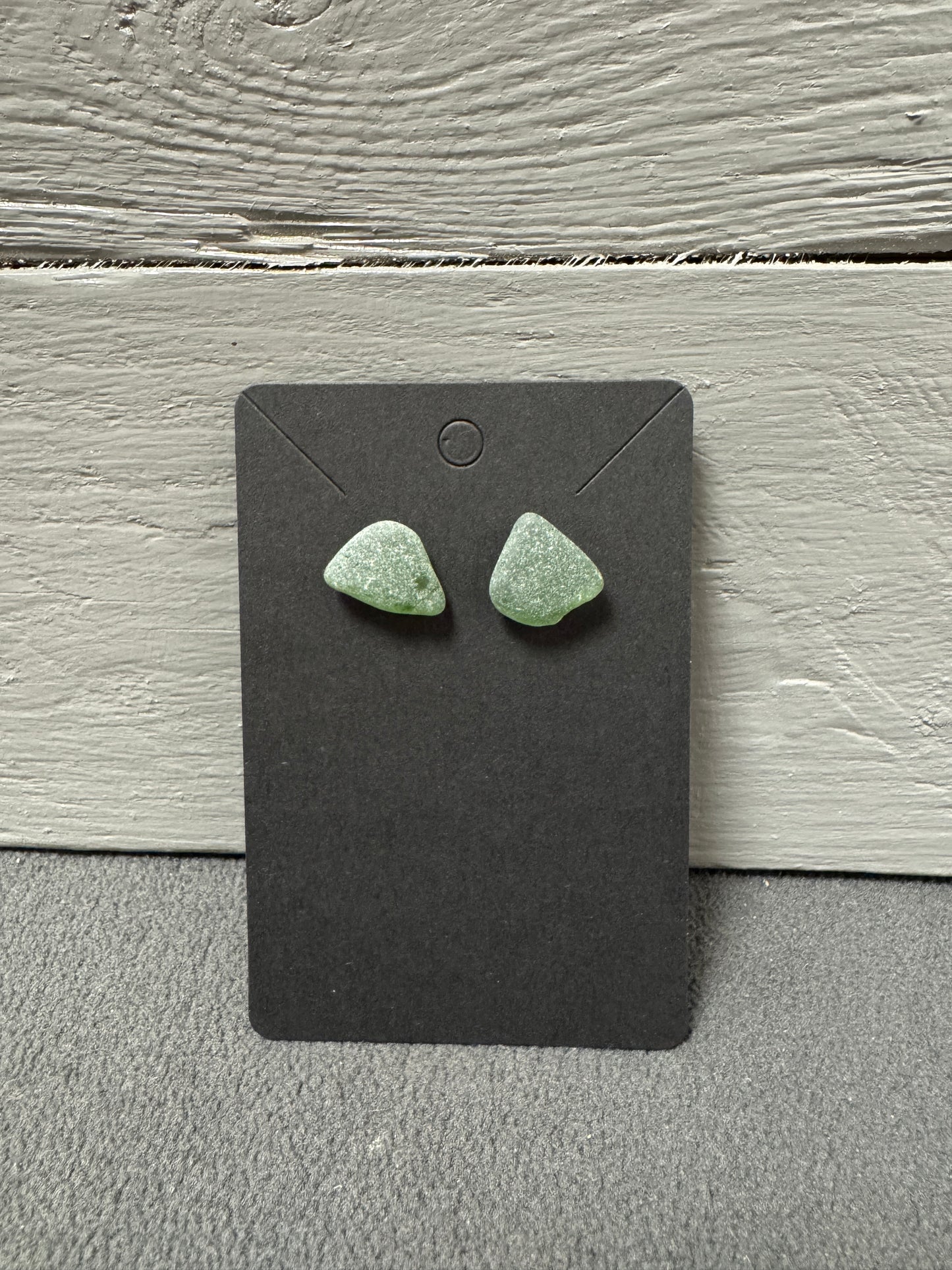 Natürliche Ohrstecker aus recyceltem Küstenglas in kräftigem Grünton.