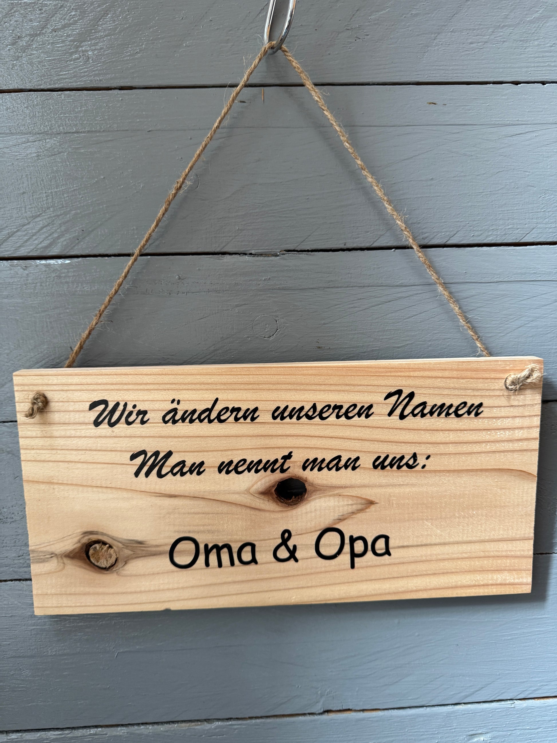 Holzschild mit Spruch „Wir ändern unseren Namen – Man nennt uns Oma & Opa“, handgefertigt, aufgehängt an Wand, liebevolle Geschenkidee für werdende Großeltern