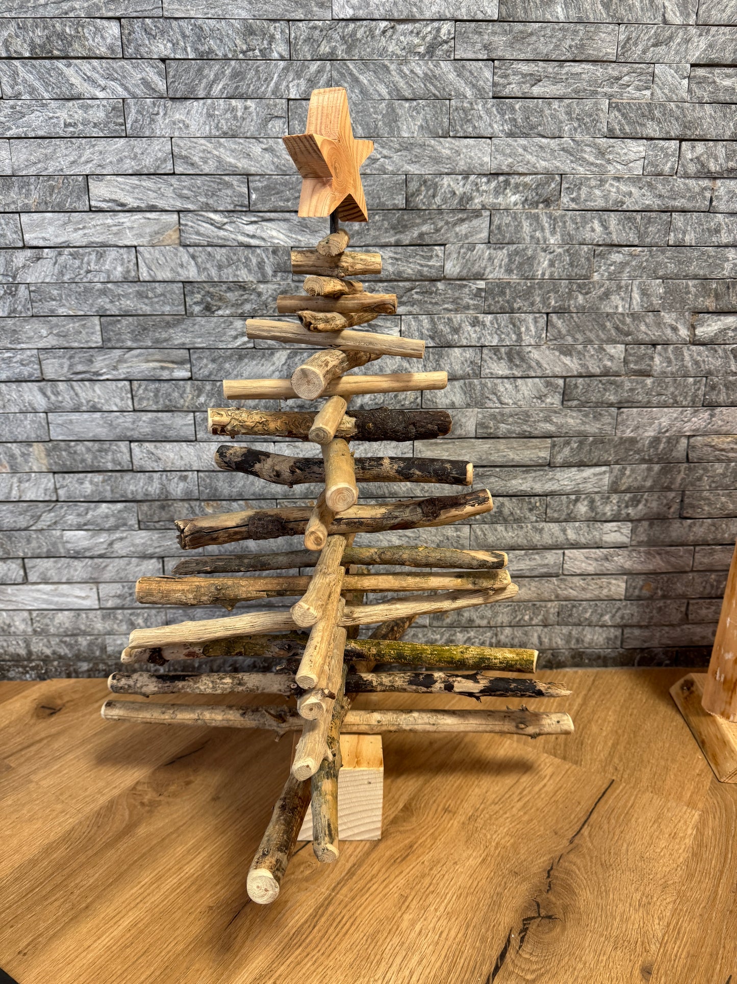 Nachhaltiger Treibholz-Weihnachtsbaum als stilvolle Wohn- und Tischdekoration, kombiniert mit Kerzen und Naturmaterialien in einem gemütlichen Wohnzimmer.