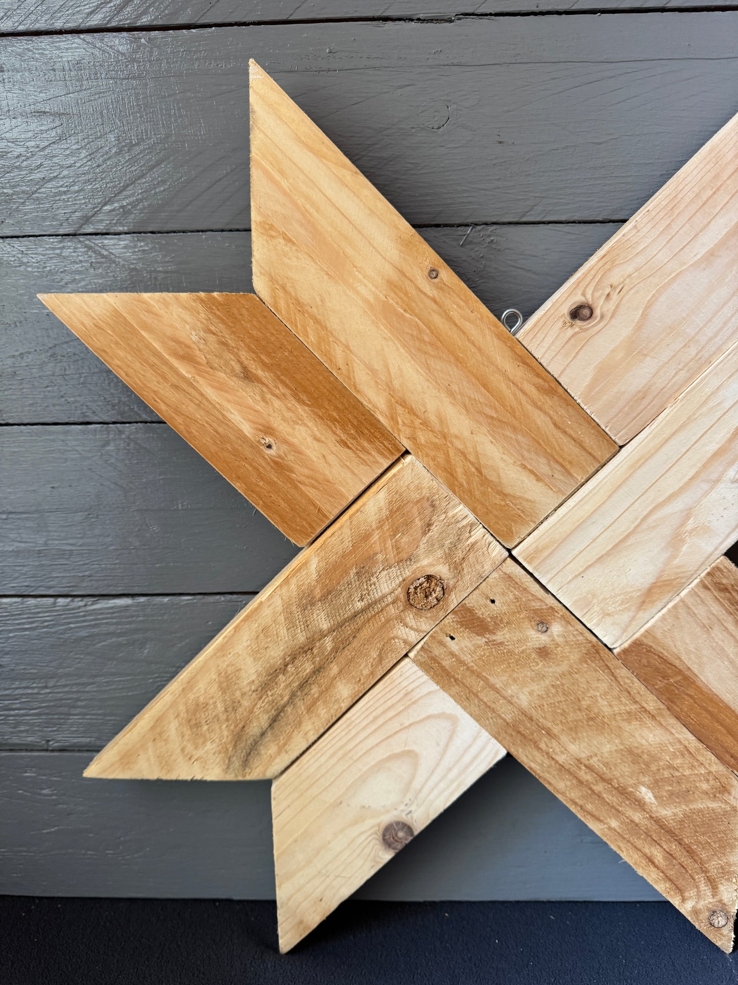 Nahaufnahme eines rustikalen Holzsterns aus Palettenholz, sichtbar natürliche Maserung und handgearbeitete Struktur.