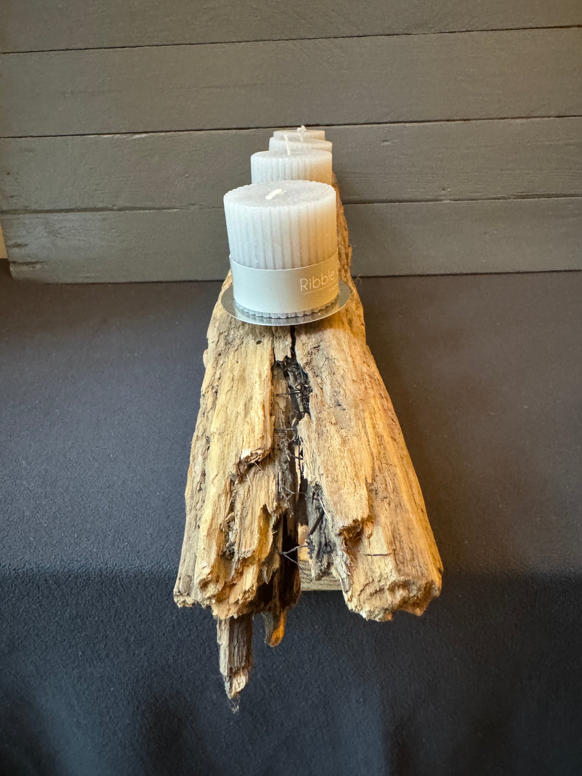 Detailaufnahme Adventsgesteck „Nordwind“ – Struktur des Ostsee-Treibholzes, geflammter Holzfuß und schlichte Teelichter im nordischen Stil.