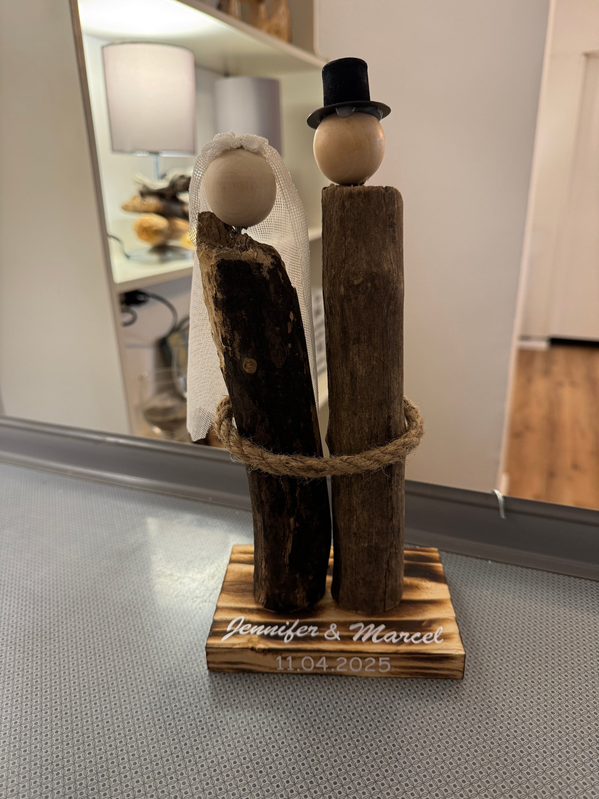 Handgefertigtes Treibholz-Brautpaar aus Ostsee-Treibholz mit Schleier und Zylinder mit Namen und Datum.