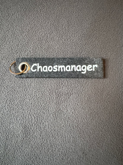Handgemachter Filzanhänger mit der Aufschrift „Chaosmanager“.