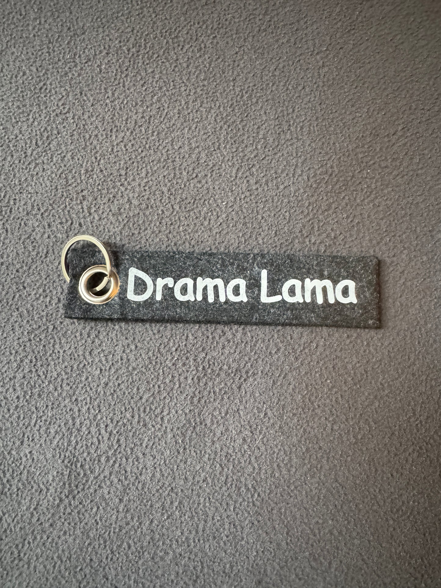Dunkel grauer Filzanhänger mit dem Spruch „Drama Lama“, humorvolle Geschenkidee.
