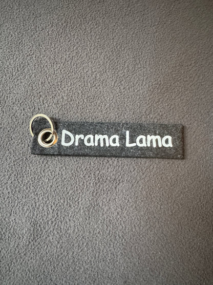 Dunkel grauer Filzanhänger mit dem Spruch „Drama Lama“, humorvolle Geschenkidee.