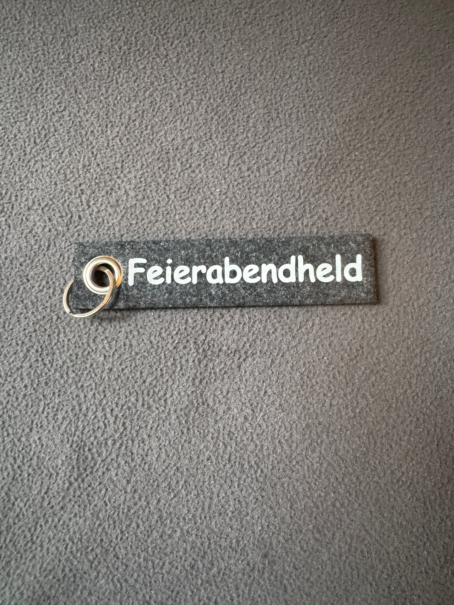 Schlüsselanhänger aus Filz mit dem Spruch „Feierabendheld“, witzige Aufmerksamkeit.