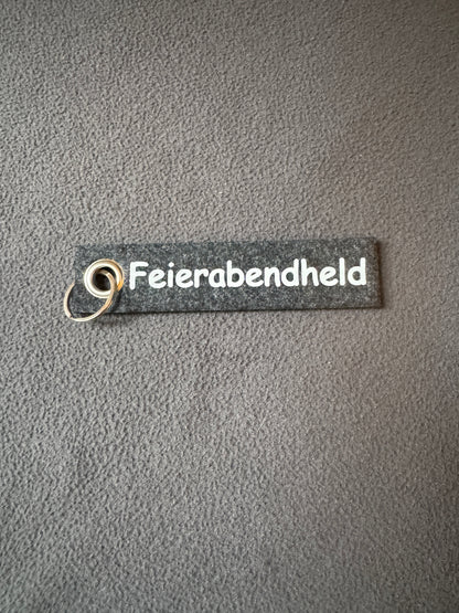Schlüsselanhänger aus Filz mit dem Spruch „Feierabendheld“, witzige Aufmerksamkeit.