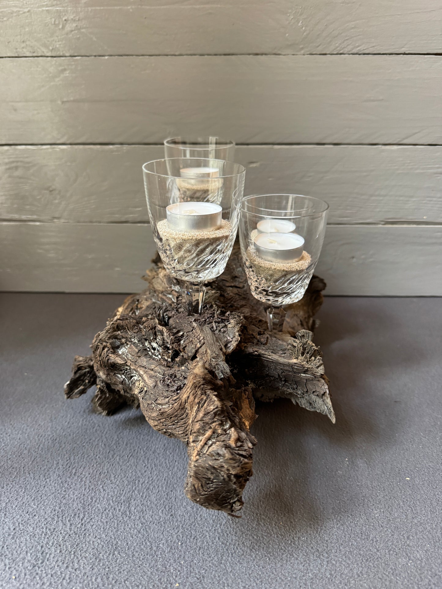 Adventsgesteck Winter – Ostsee-Treibholz mit gläsernen Kerzenhaltern und sanftem Licht für eine festliche Stimmung.