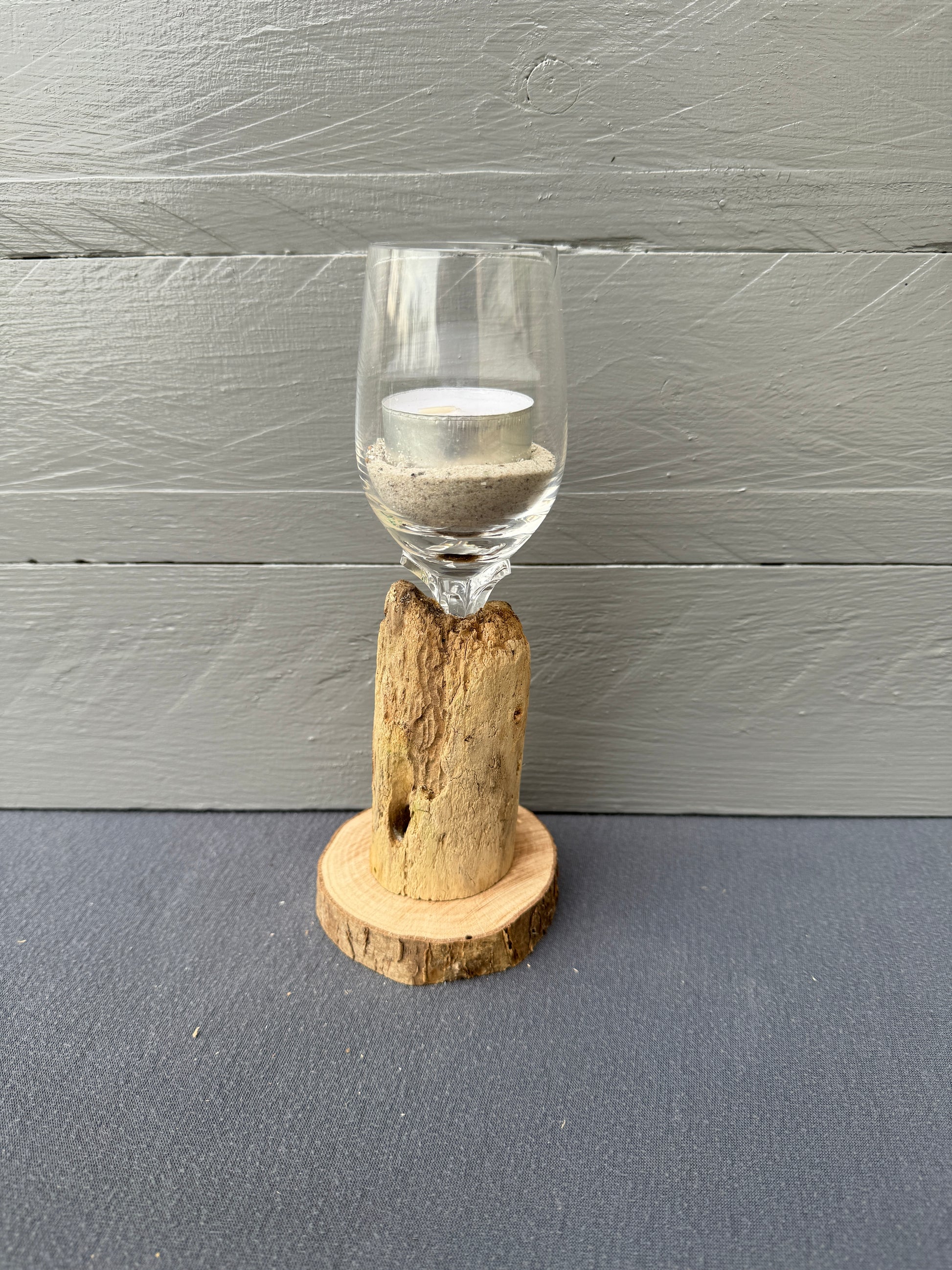 Kerzenständer mit Sand gefülltem Glas auf Baumscheibe