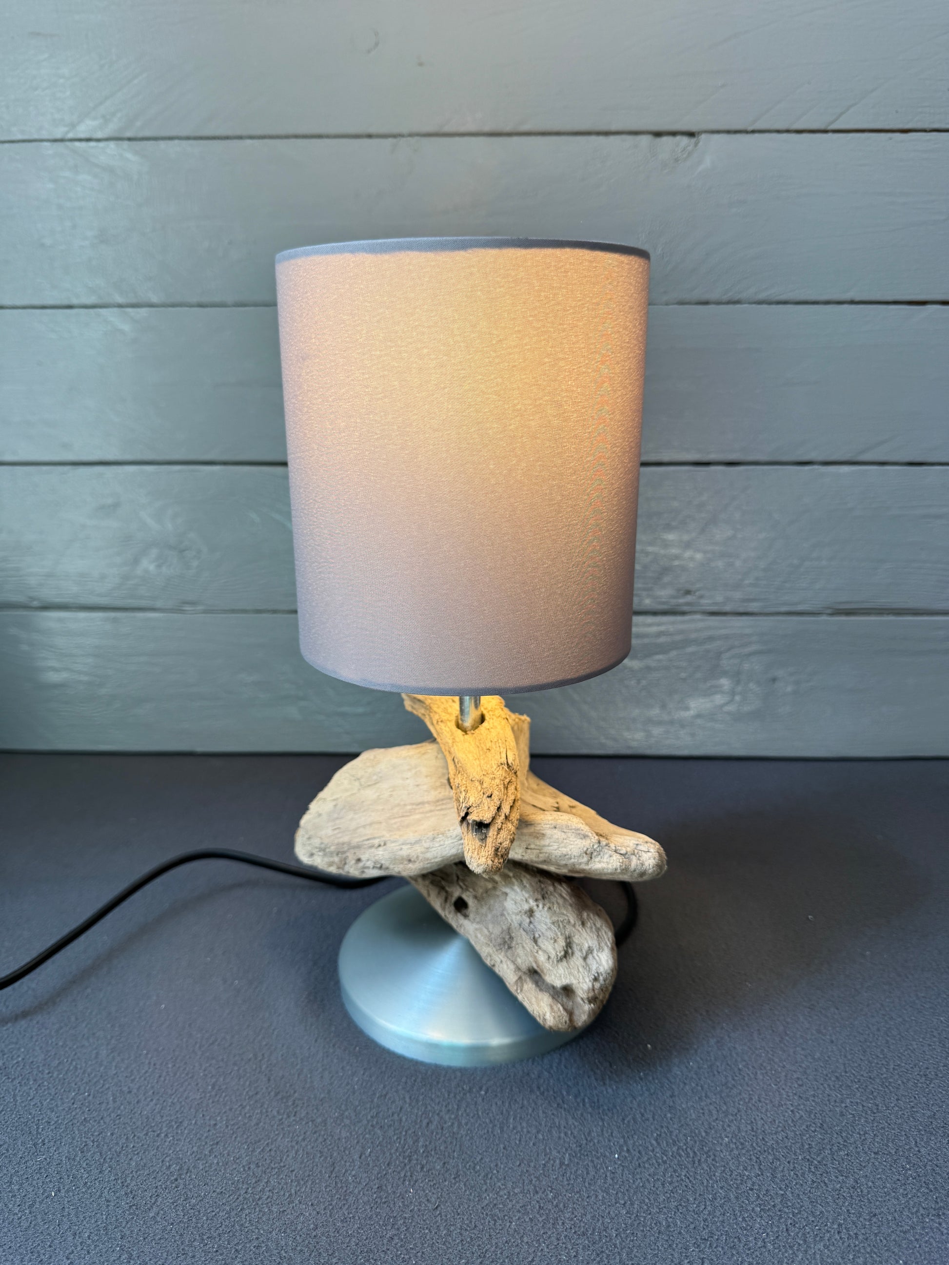 Handgemachte Treibholzlampe mit natürlicher Holzstruktur und Stoffschirm.