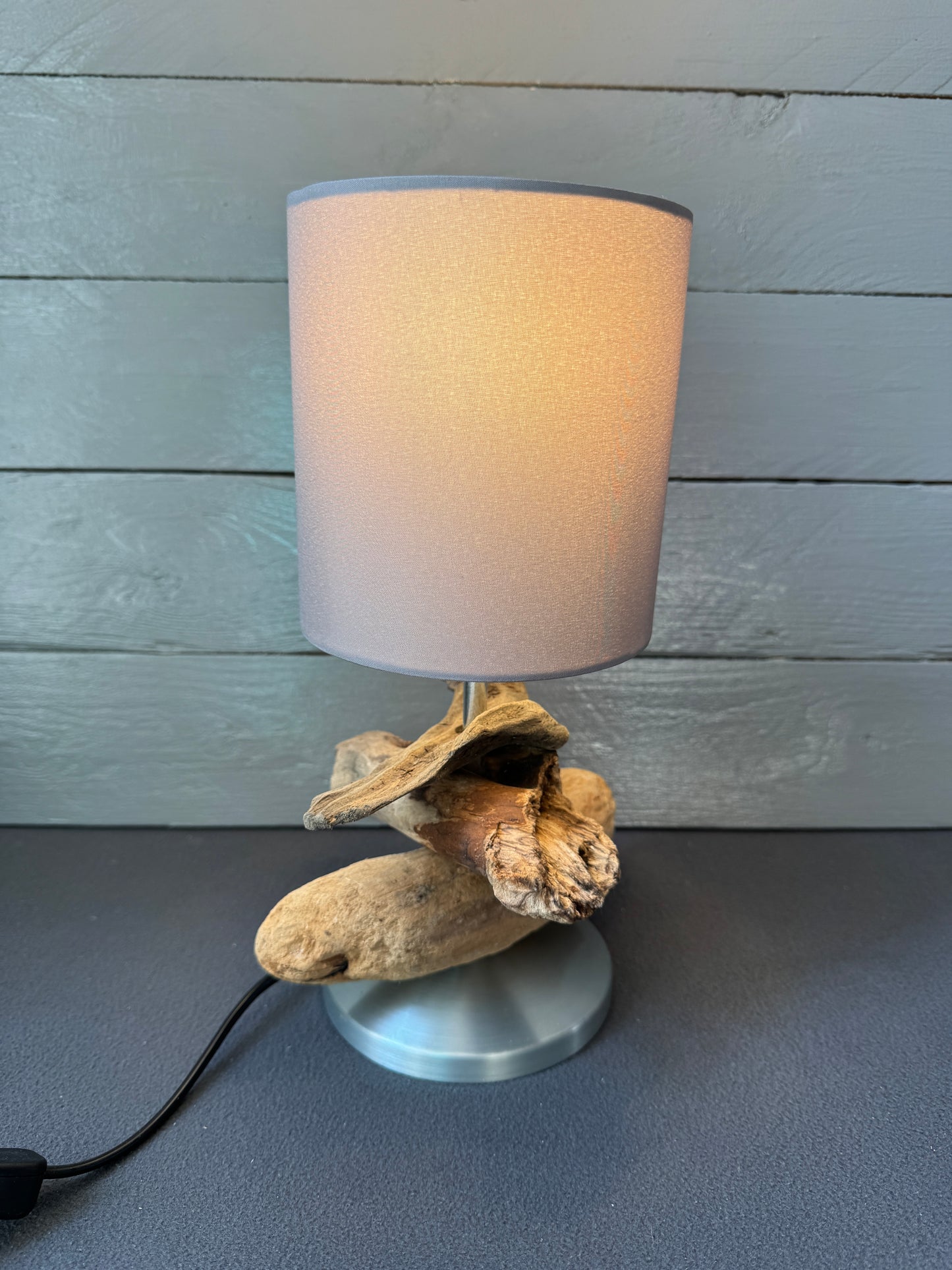 Maritime Tischlampe aus Treibholz mit warmem Licht und modernem Lampenschirm.