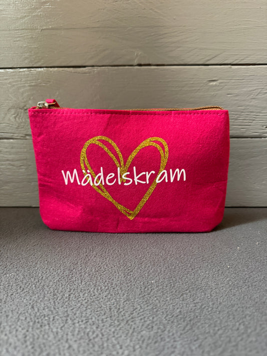 Kosmetiktasche aus Filz in Pink mit goldenem Herz und Schriftzug „Mädelskram“.