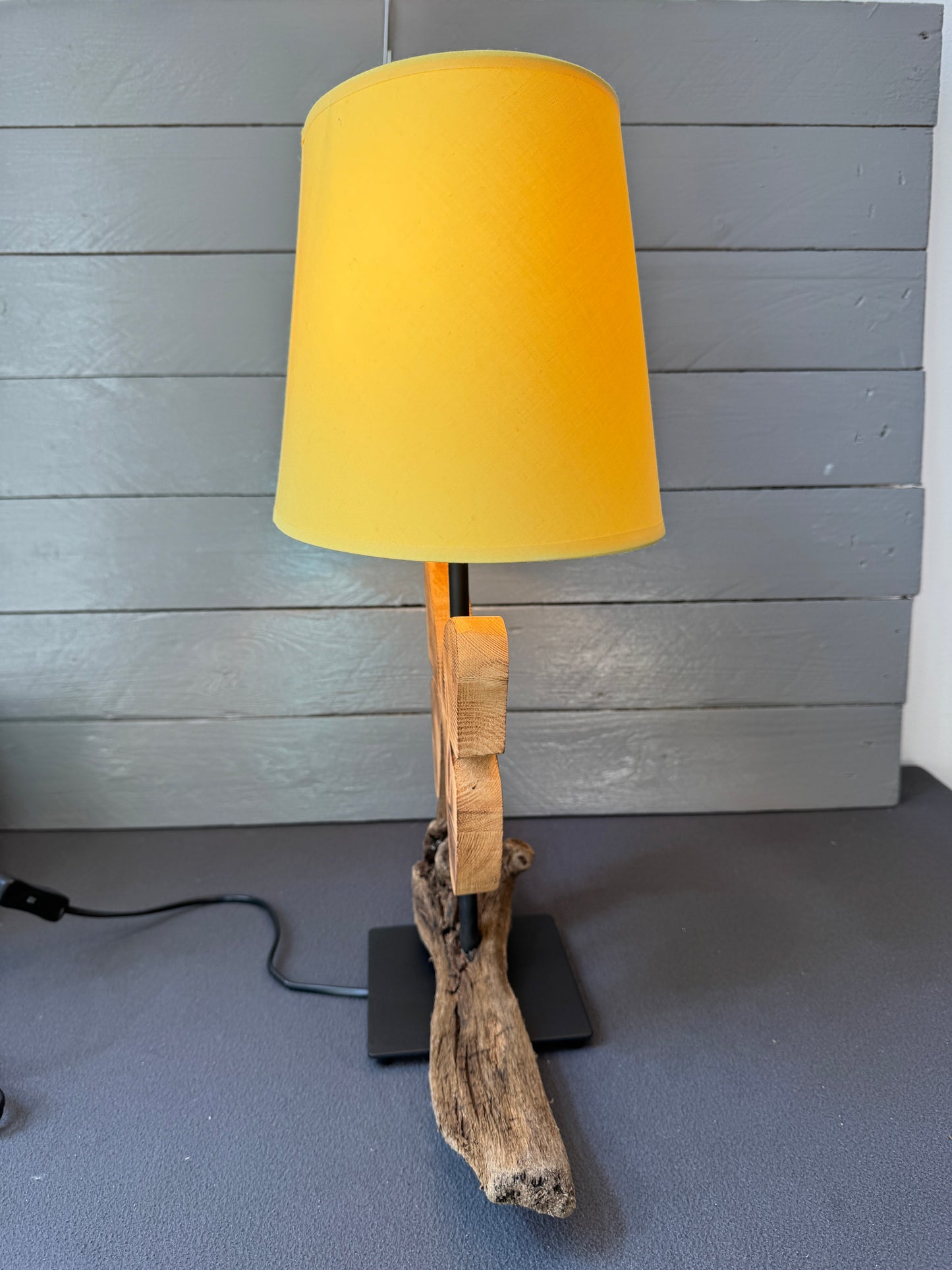 Handgemachte Treibholzlampe mit geschnitztem Altholz-Schmetterling und warmem Lampenschirm.