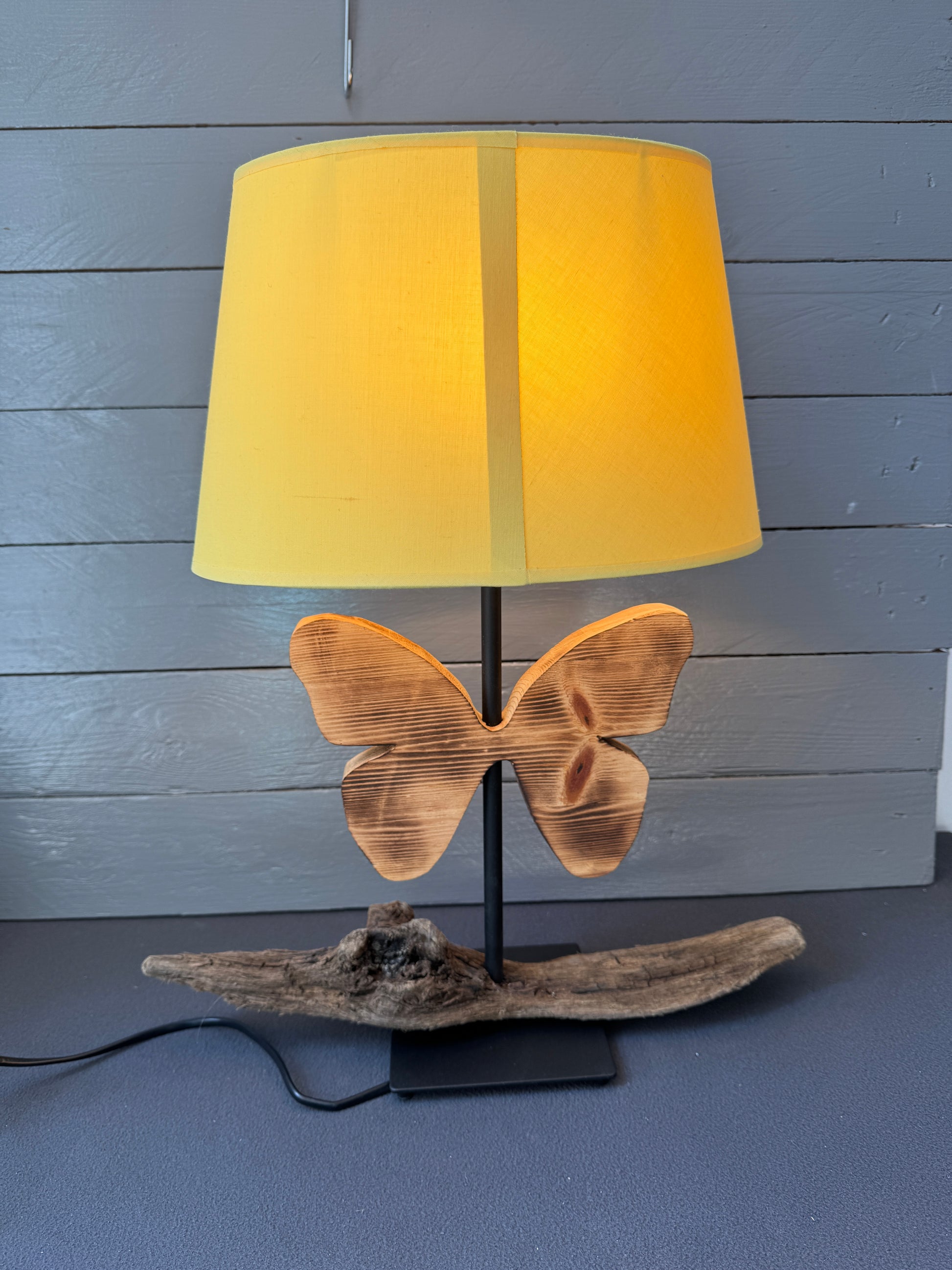 Nachhaltige Tischlampe aus Ostsee-Treibholz mit dekorativem Schmetterling aus Altholz, maritimer Wohnstil.