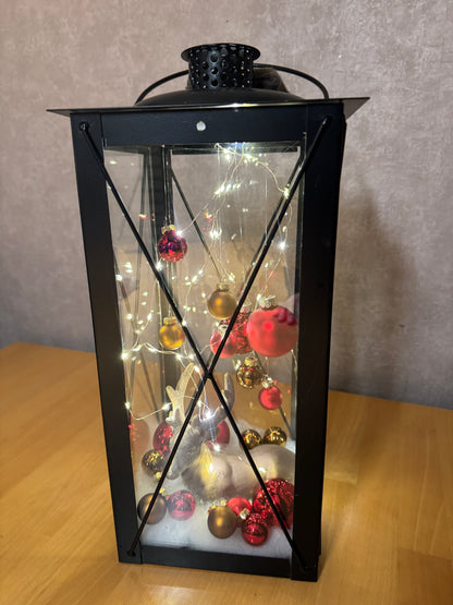 Weihnachtslaterne mit Hirsch – handgemachtes Unikat aus Metall und Glas, gefüllt mit winterlicher Dekoration.