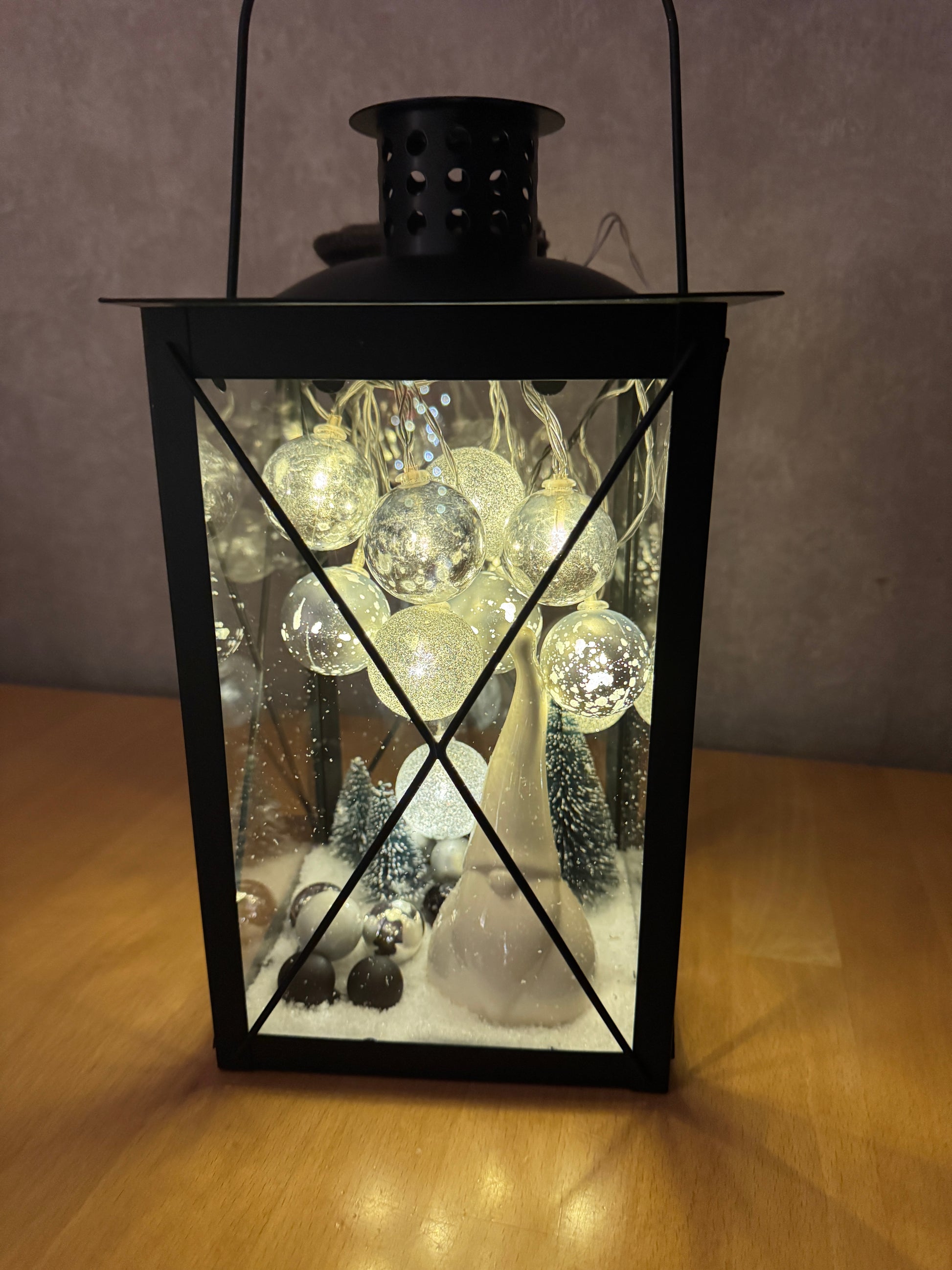Handgefertigte Weihnachtslaterne mit LED-Lichtern, glitzernden Kugeln und Winterlandschaft – festliche Deko mit Schneeeffekt.