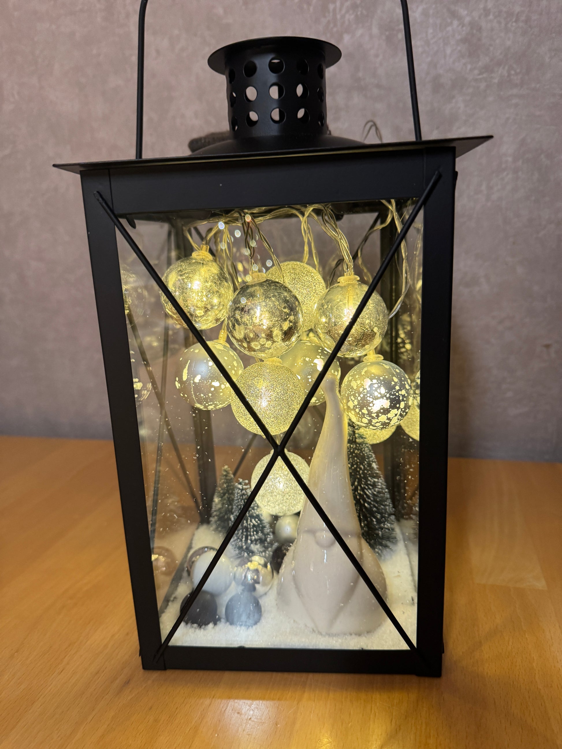 Detailaufnahme der Weihnachtslaterne – Wichtelfigur zwischen Schneelandschaft, Tannenbäumchen und funkelnden Lichterkugeln.