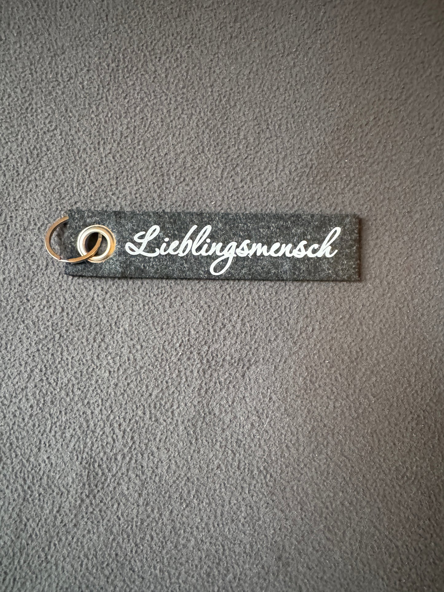 Grauer Filz-Schlüsselanhänger mit dem Spruch „Lieblingsmensch“, handgemacht und nachhaltig.