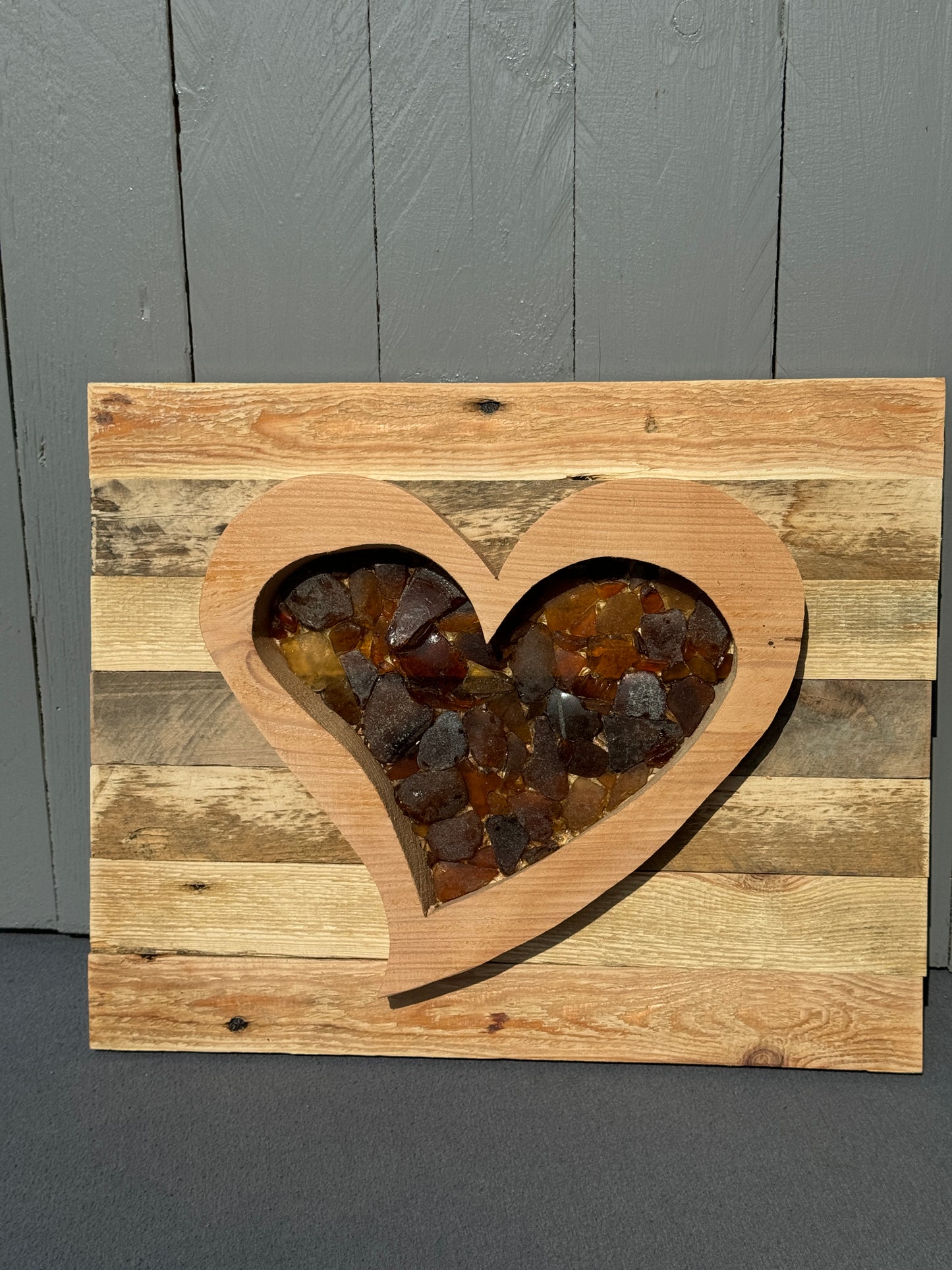 Maritimes Wandbild mit braunem Meerglasherz – Nachhaltige Wanddeko aus Ostsee-Fundstücken