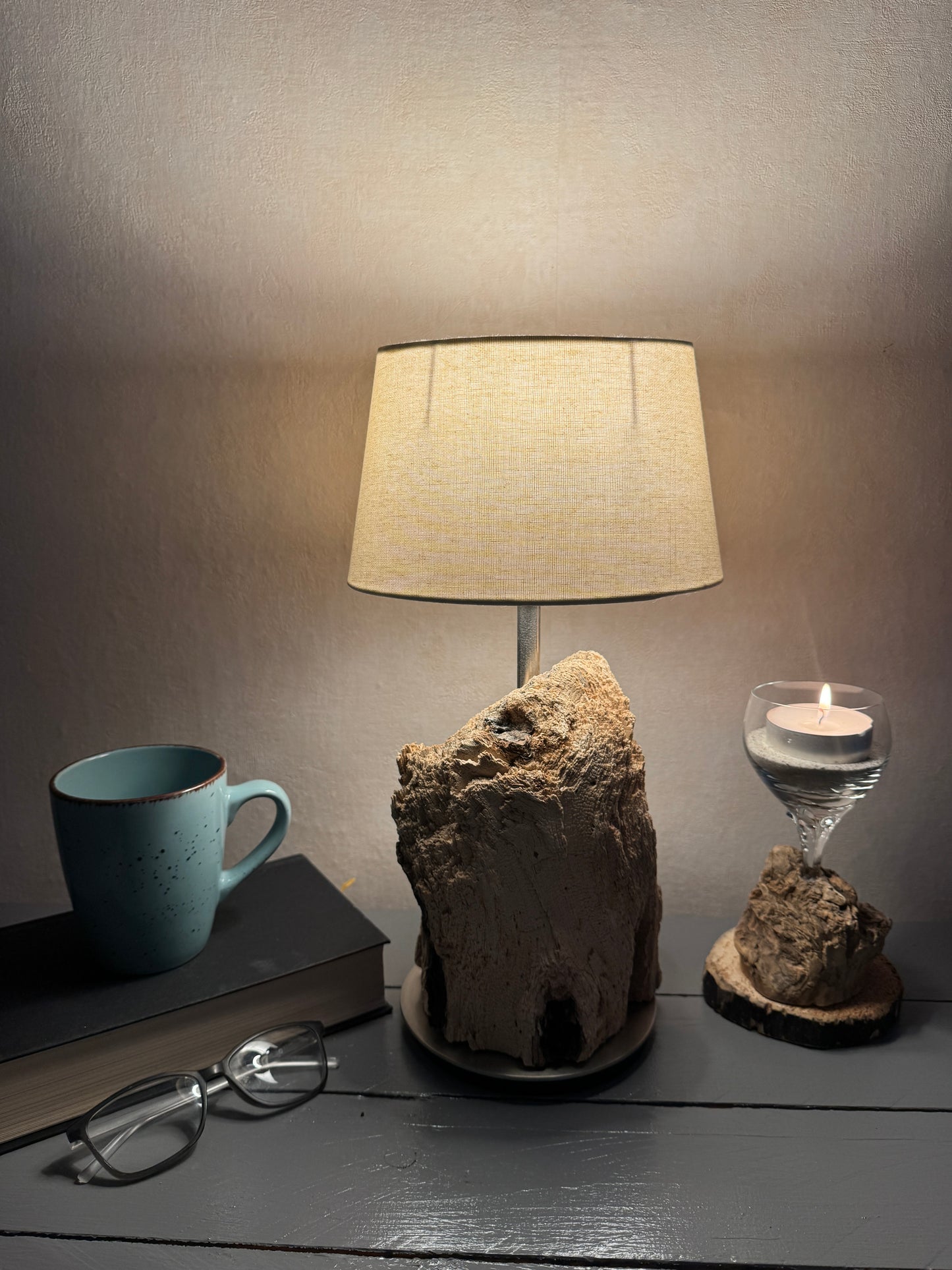 Treibholzlampe mit ovalem beigem Lampenschirm eingeschaltet