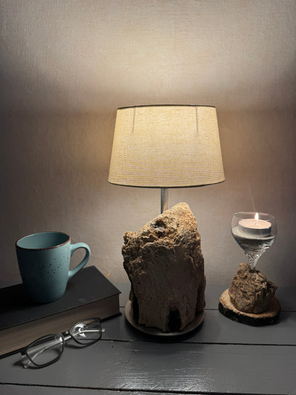 Treibholzlampe mit ovalem beigem Lampenschirm eingeschaltet