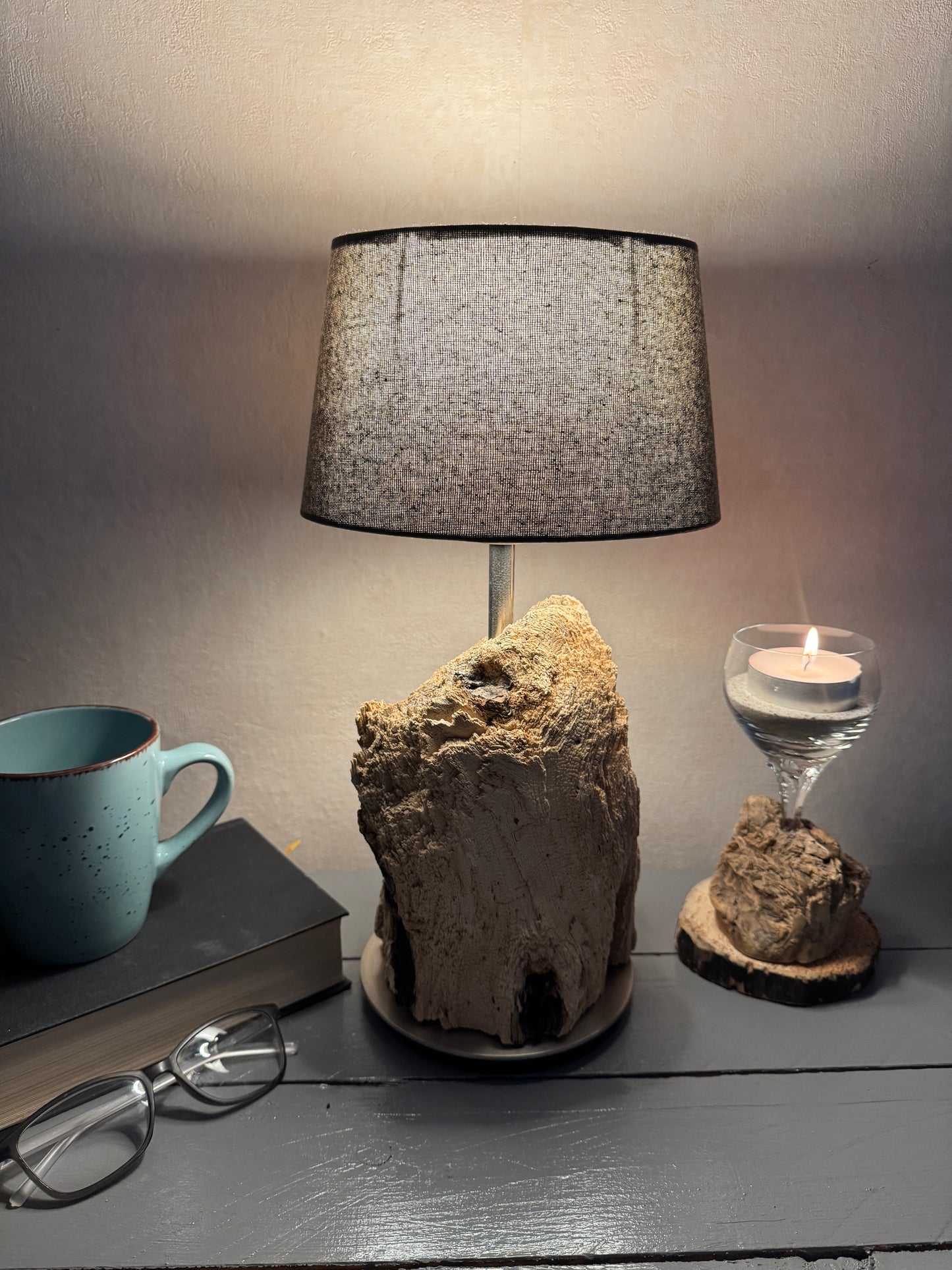 Treibholzlampe mit ovalem grauem Lampenschirm im warmen Licht