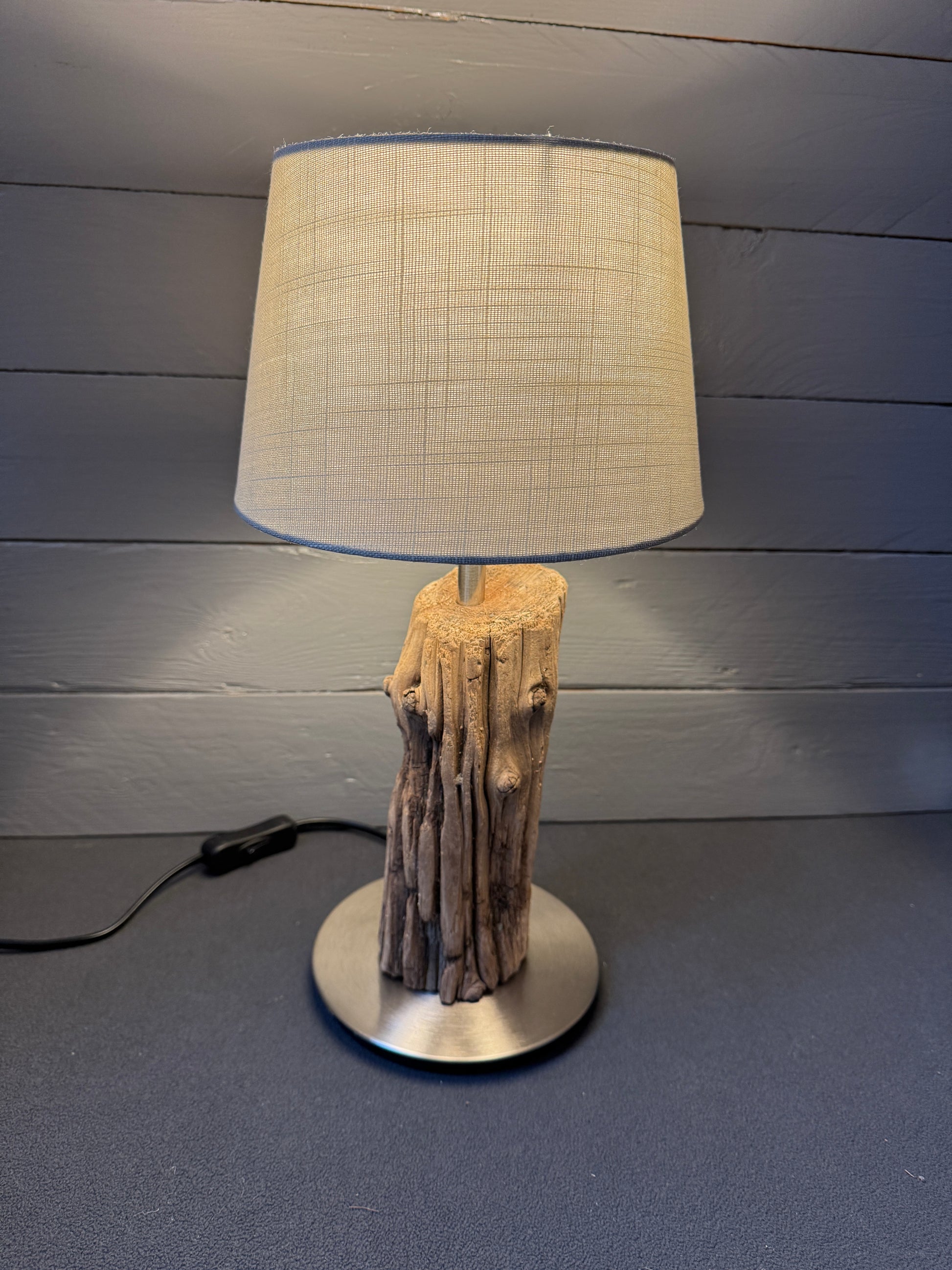 Seitenansicht: Kombination aus minimalistischem Fuß und rauem Holz