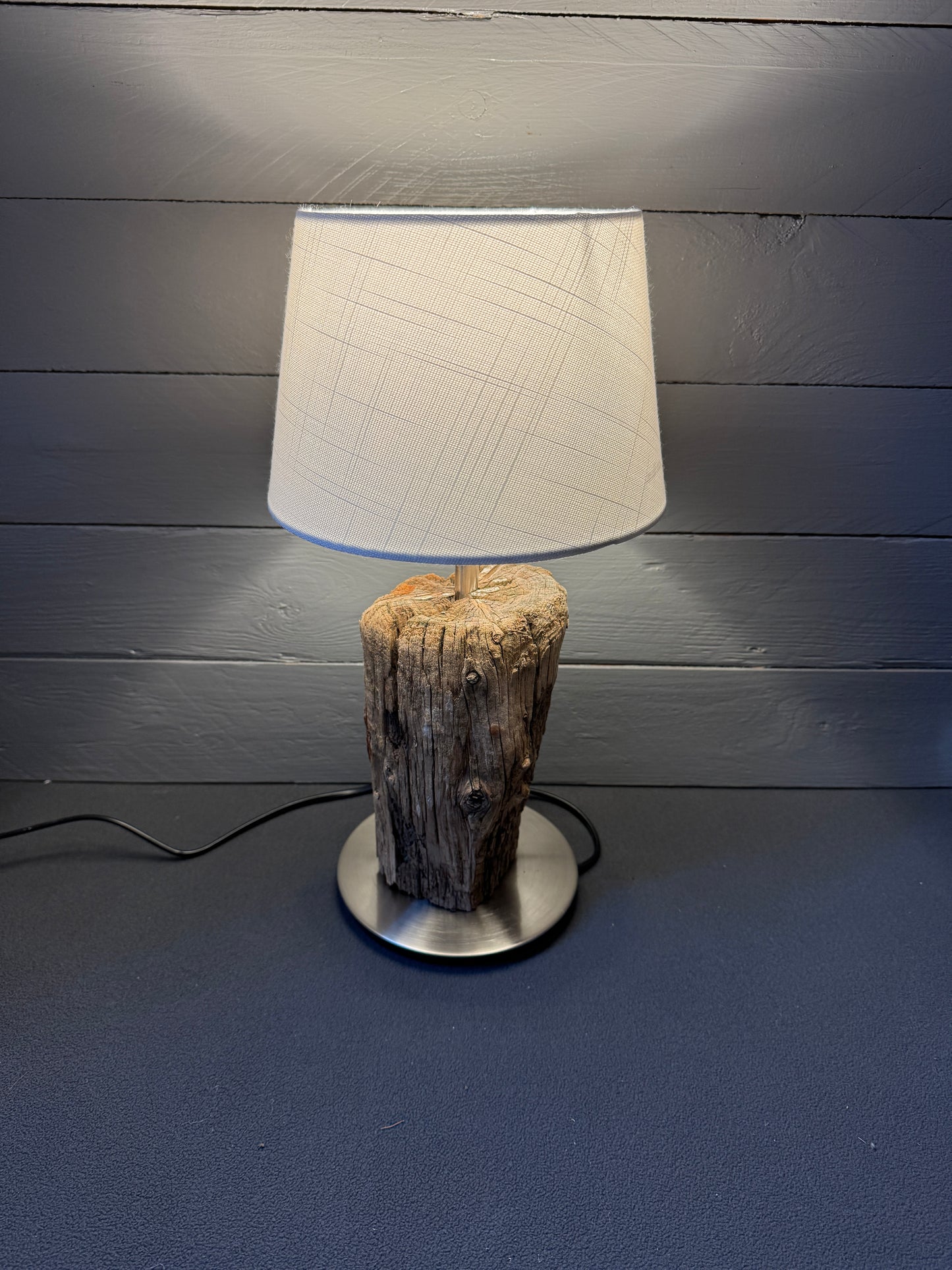 Seitenansicht: Kombination aus minimalistischem Fuß und rauem Holz