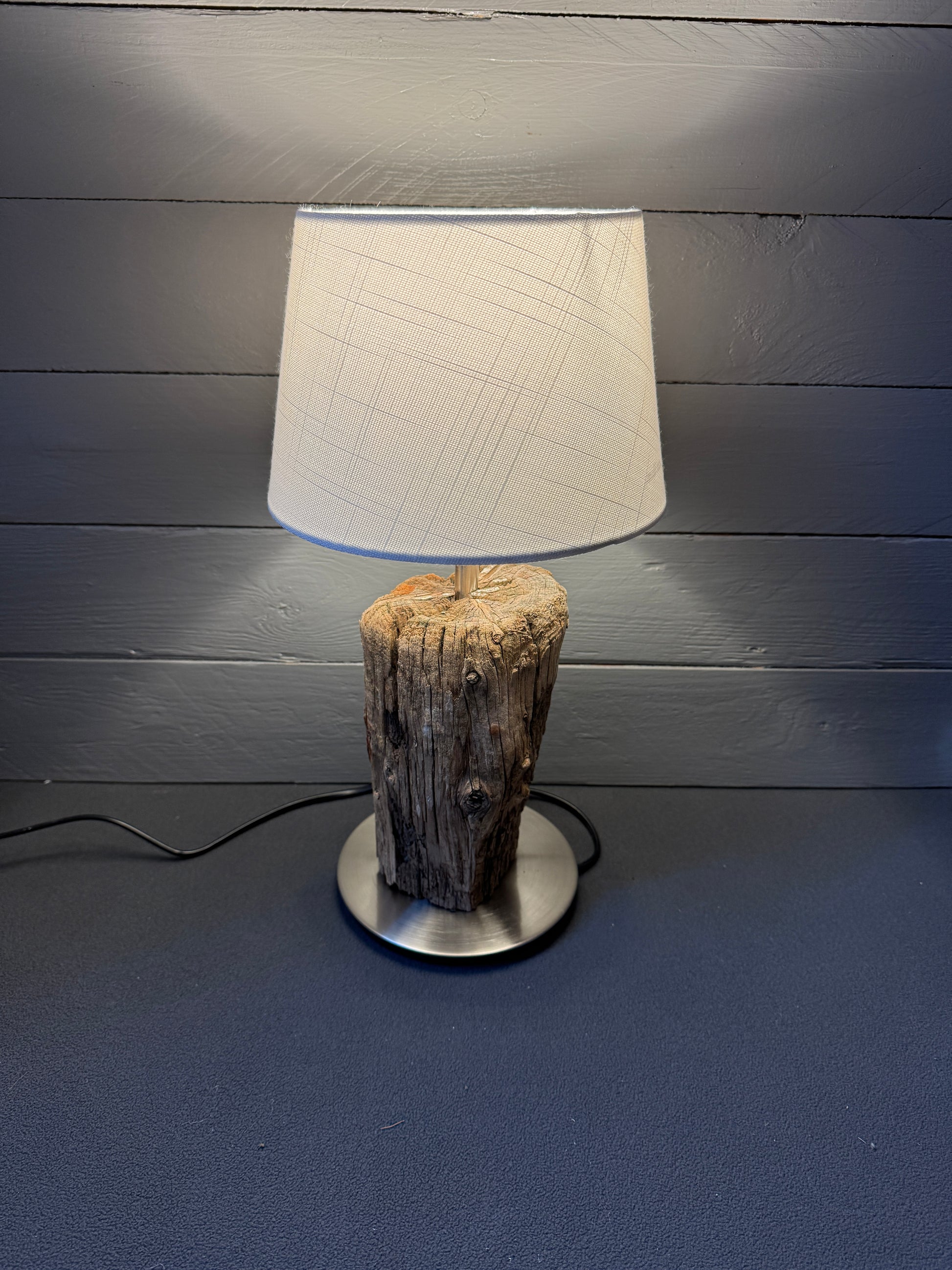 Seitenansicht: Kombination aus minimalistischem Fuß und rauem Holz