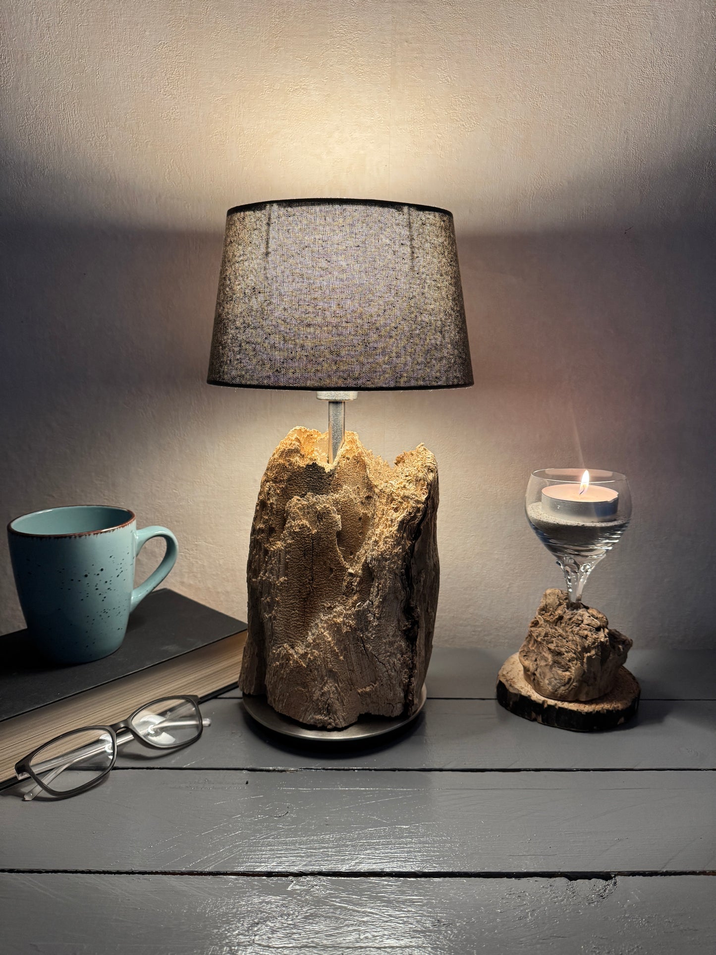 Treibholzlampe mit ovalem grauem Lampenschirm eingeschaltet