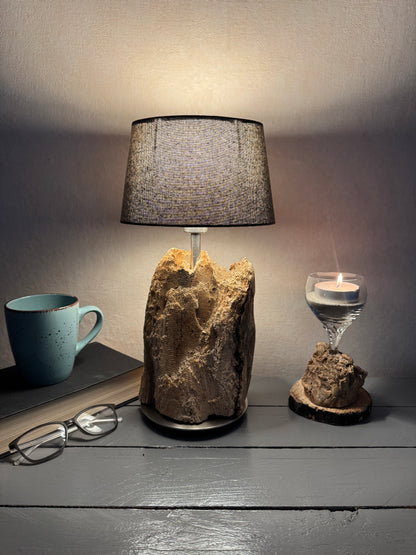 Treibholzlampe mit ovalem grauem Lampenschirm eingeschaltet