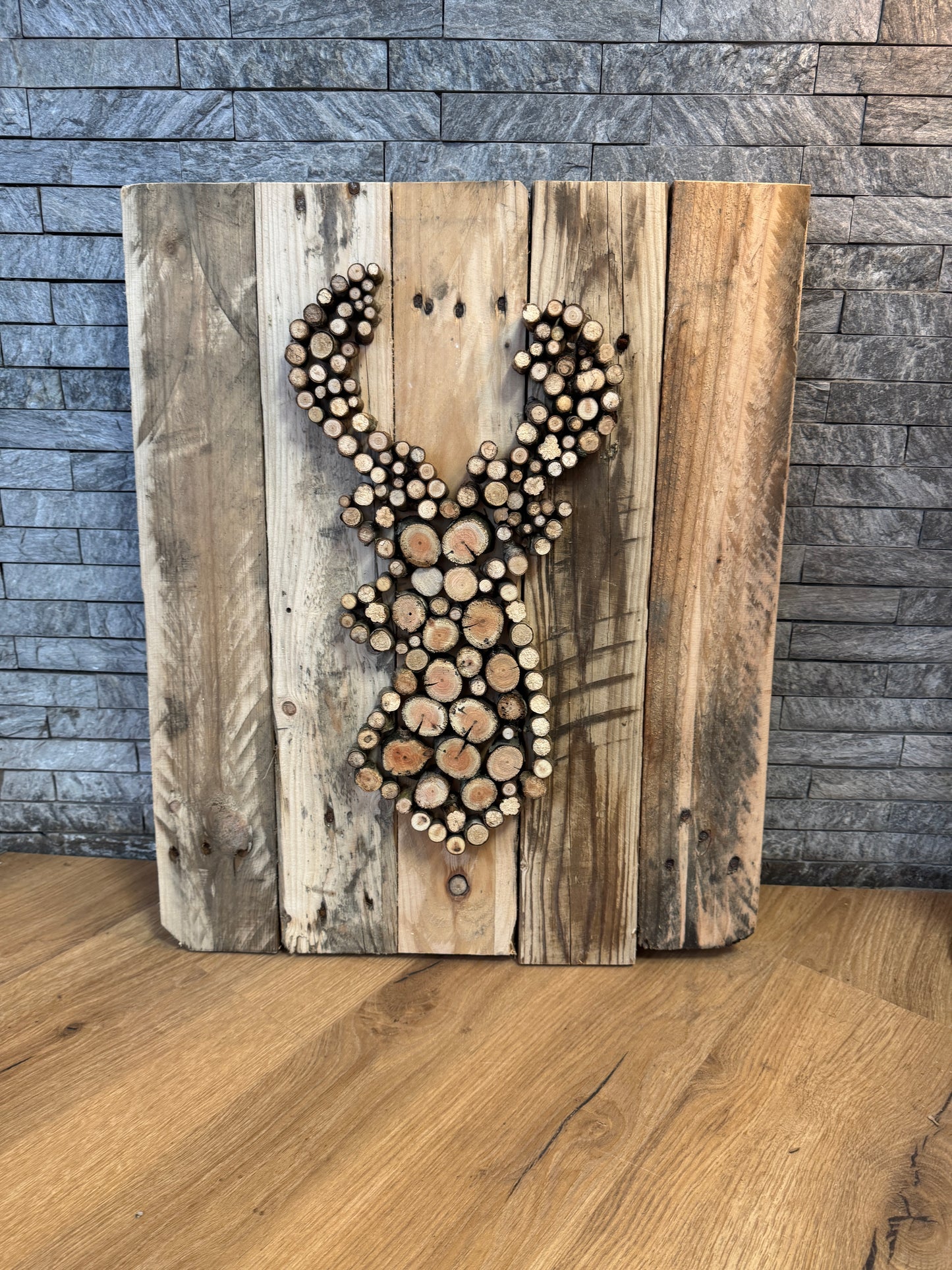 Handgefertigtes Hirschkopf-Wandbild aus Palettenholz und Astscheiben – rustikale Naturdeko.