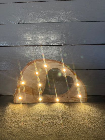 Handgefertigte Baumscheibe aus Naturholz mit eingesägtem Herz und warmweißer LED-Lichterkette