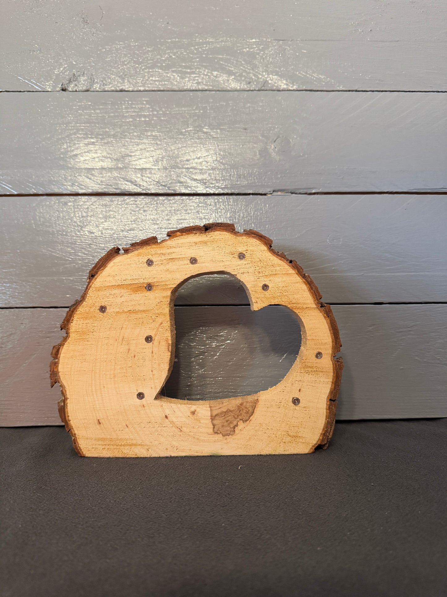 Baumscheibe aus Naturholz mit eingesägtem Herz und LED-Beleuchtung – markante Holzstruktur