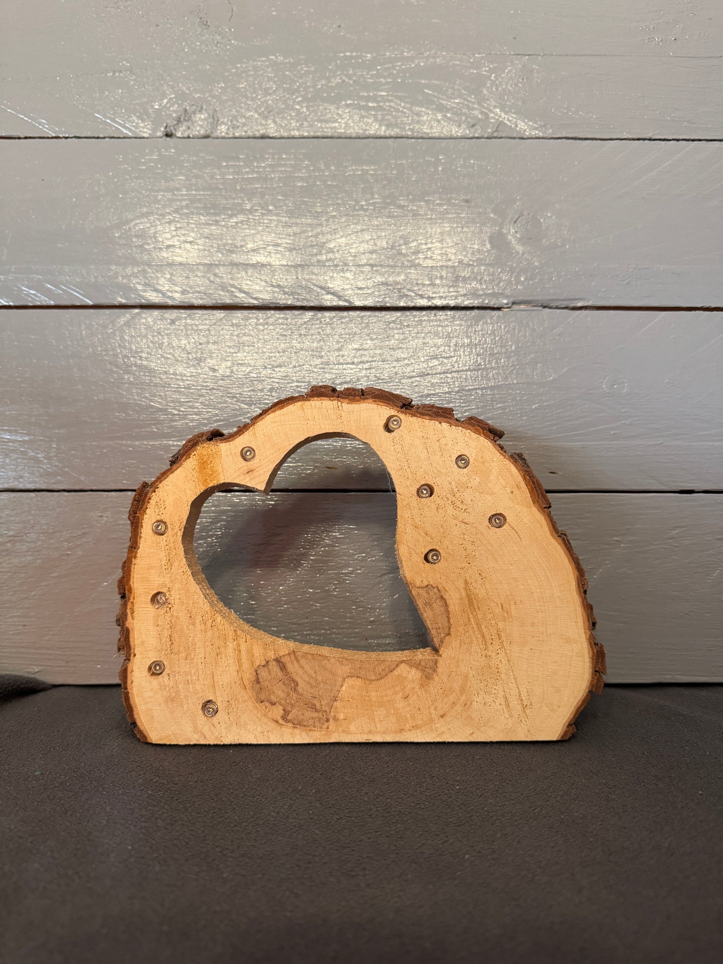 Baumscheibe mit Herzmotiv und warmweißer LED – rustikale Holzstruktur mit natürlicher Rinde