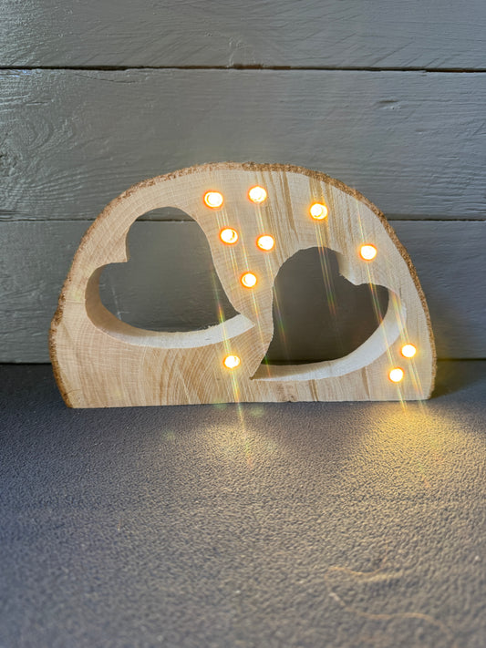 Handgemachte Baumscheibe aus Holz mit zwei Herzen und LED-Lichterkette als liebevolles Geschenk