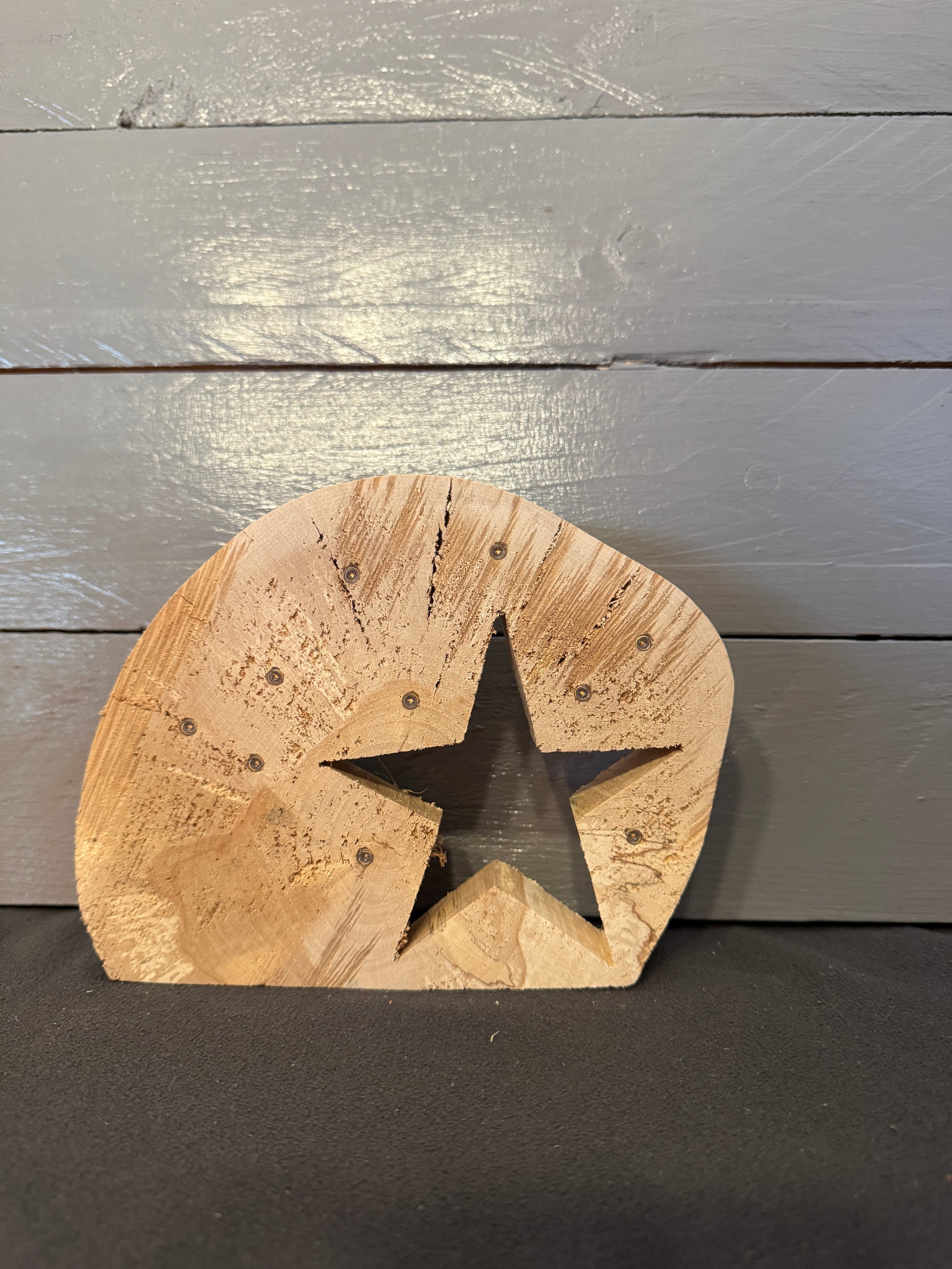 Baumscheibe mit Stern und warmem LED-Licht als stimmungsvolle Gedenkdeko im Wohnraum