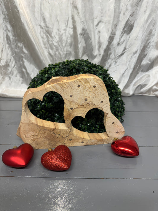 Baumscheibe aus Birkenholz mit zwei ausgesägten Herzen als handgefertigtes Holzgeschenk.