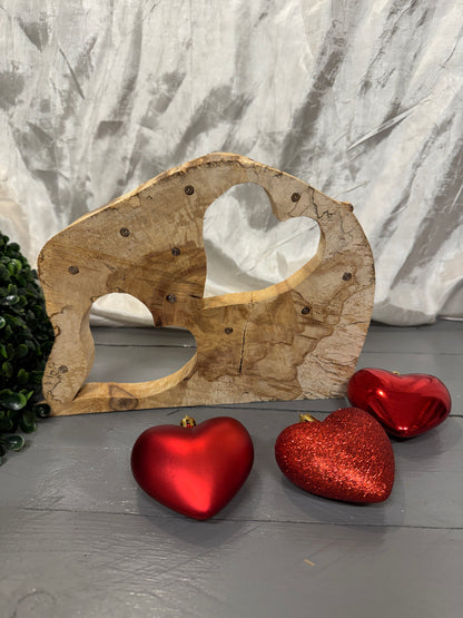 Einzigartige Baumscheibe aus Birkenholz mit zwei Herzen als nachhaltiges Holzgeschenk.