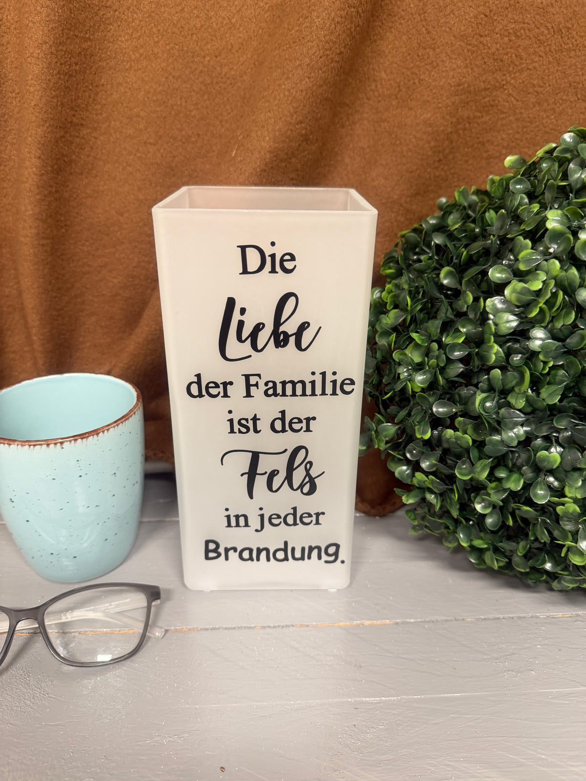Glaslampe mit Spruch über Familie und Zusammenhalt in unbeleuchtetem Zustand.