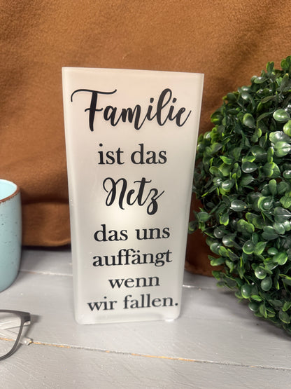 Glaslampe mit Familienspruch und warmem Licht in unbeleuchtetem Zustand.