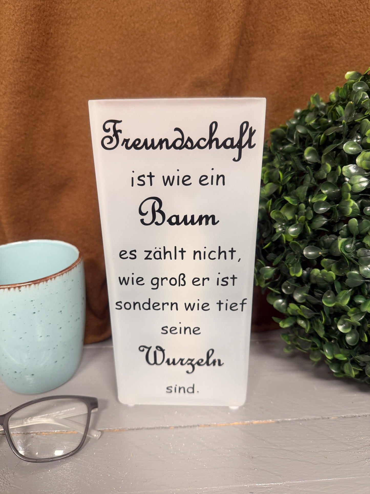 Glaslampe mit Spruch über Freundschaft und tiefe Wurzeln unbeleuchtet.